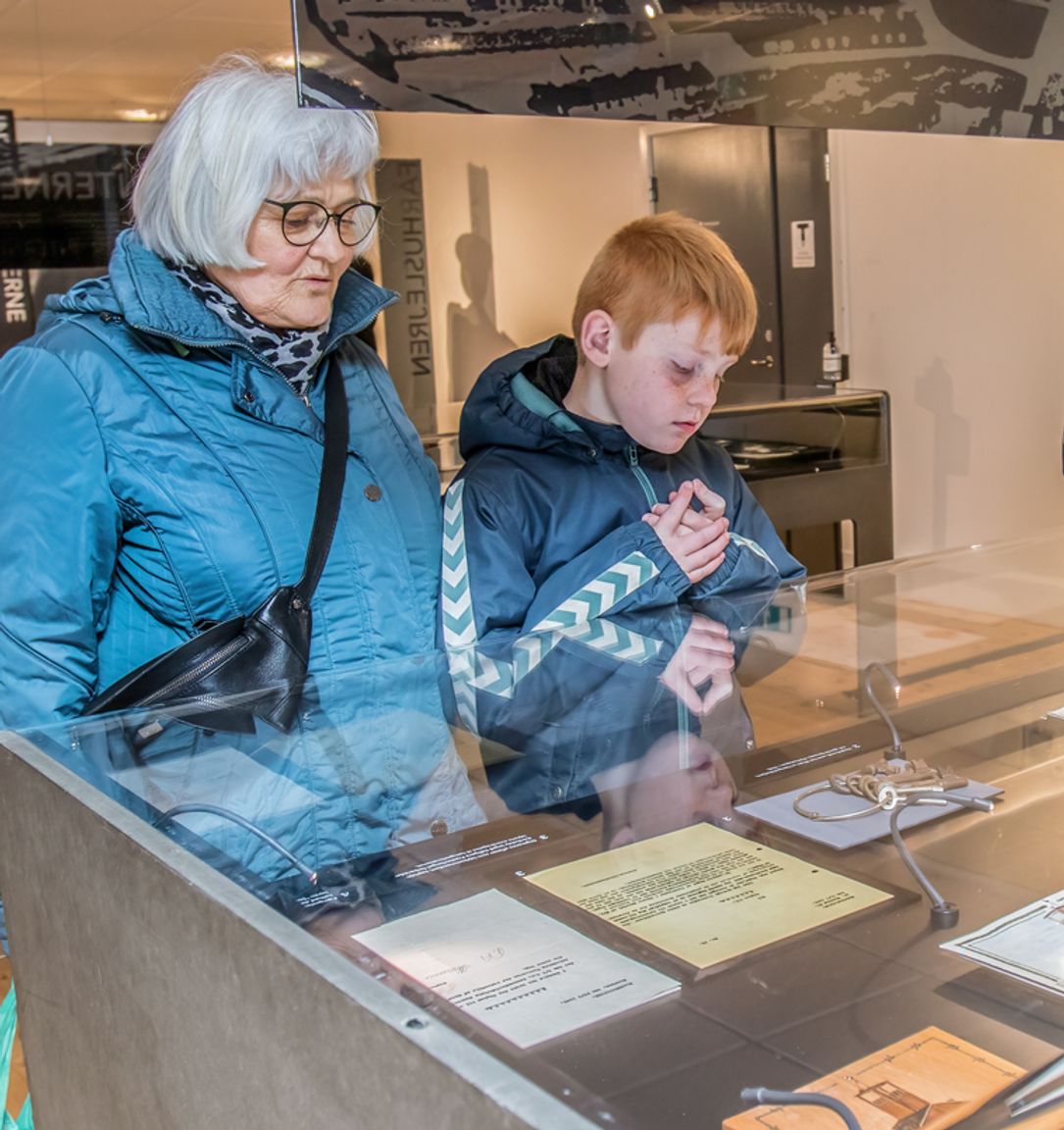 Guests view historical artifacts in an exhibition about the Faarhus camp