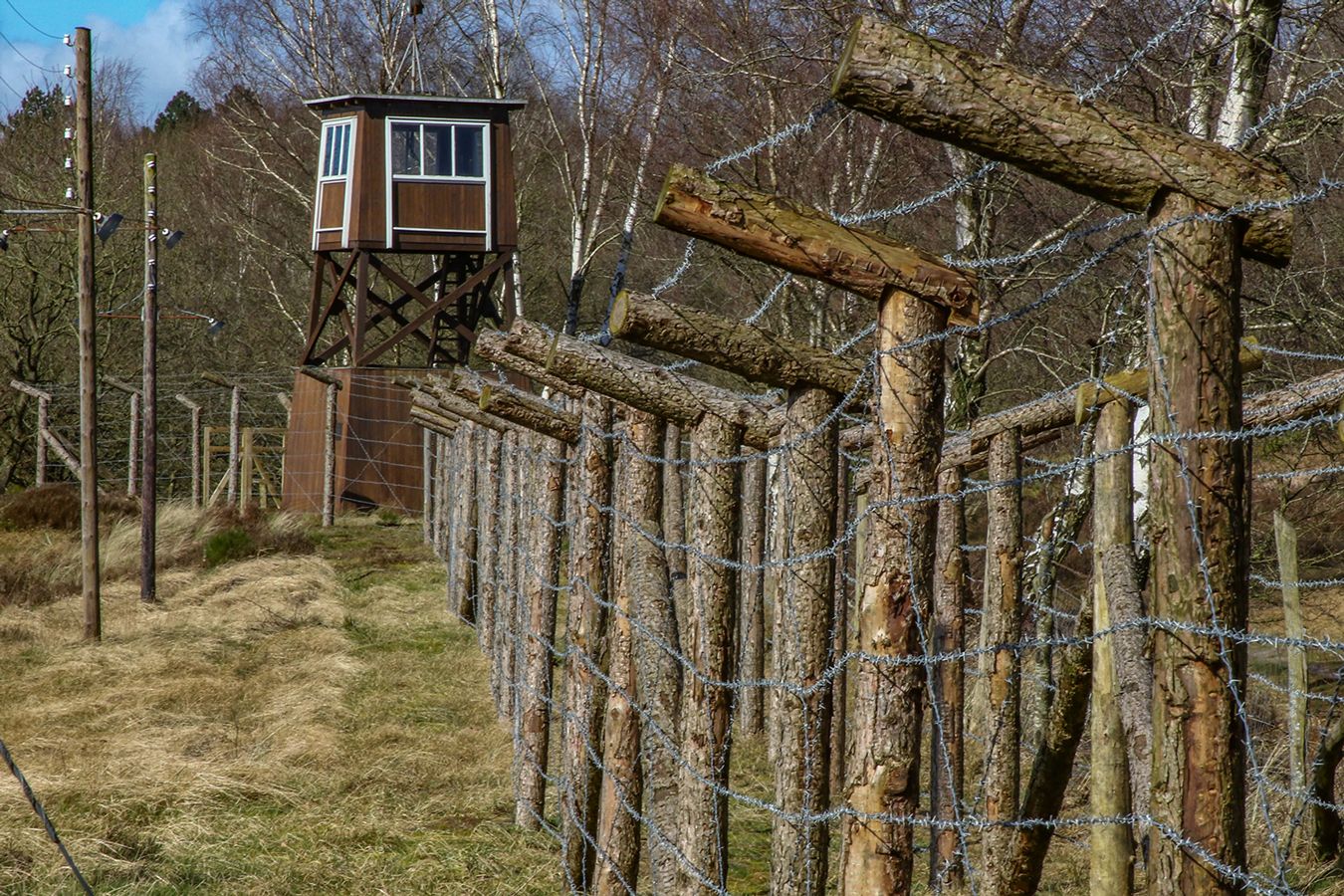 Watchtower and wooden fence with barbed wire along the original camp perimeter at Frøslev Camp