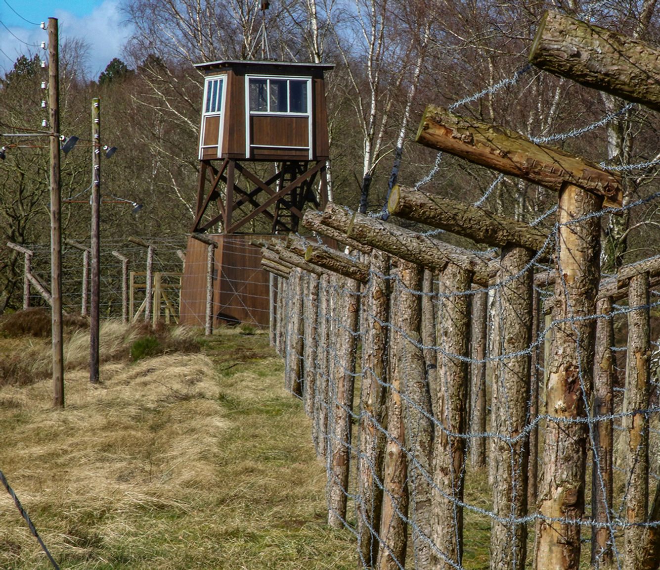 Watchtower and wooden fence with barbed wire along the original camp perimeter at Frøslev Camp