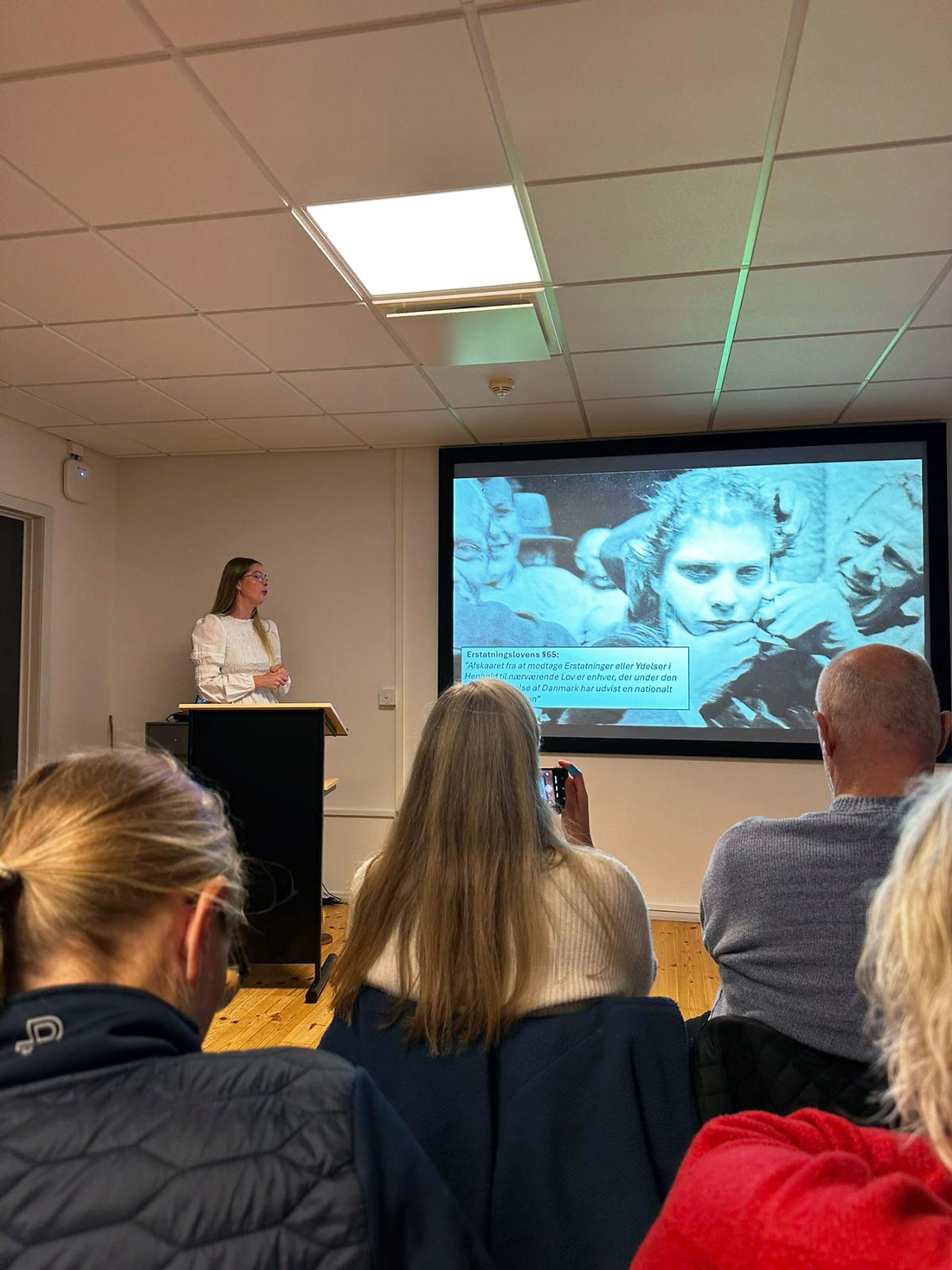 A group attends a lecture on the Faarhus camp in the Frøslev camp.