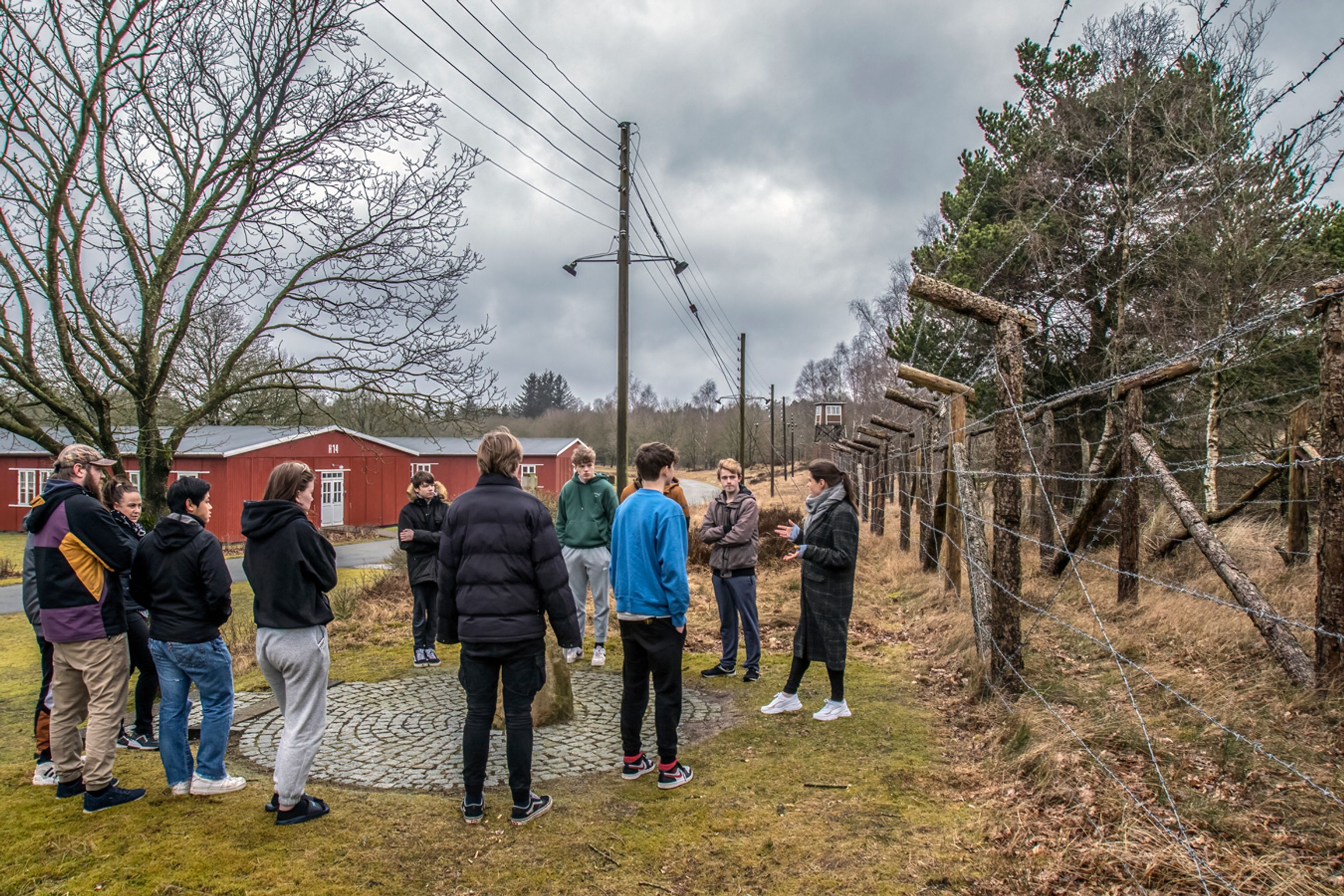 A group of students are on a tour and are standing by Preben's Stone.
