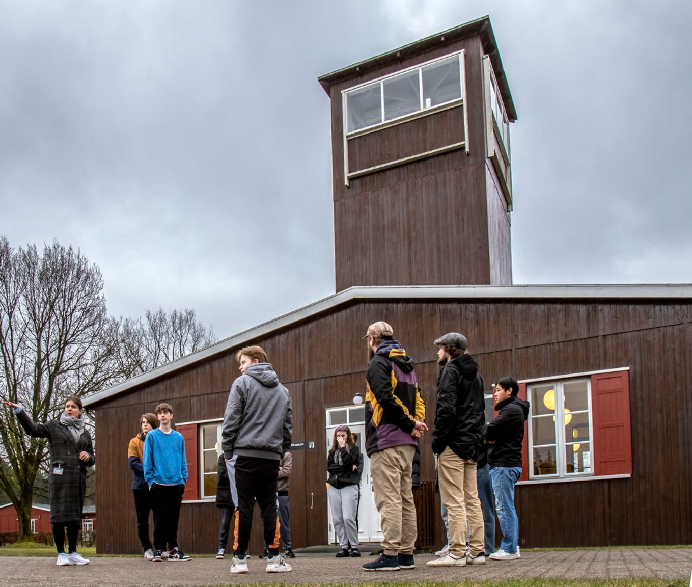 A group of students stands in front of the main guard tower at Frøslev Camp.