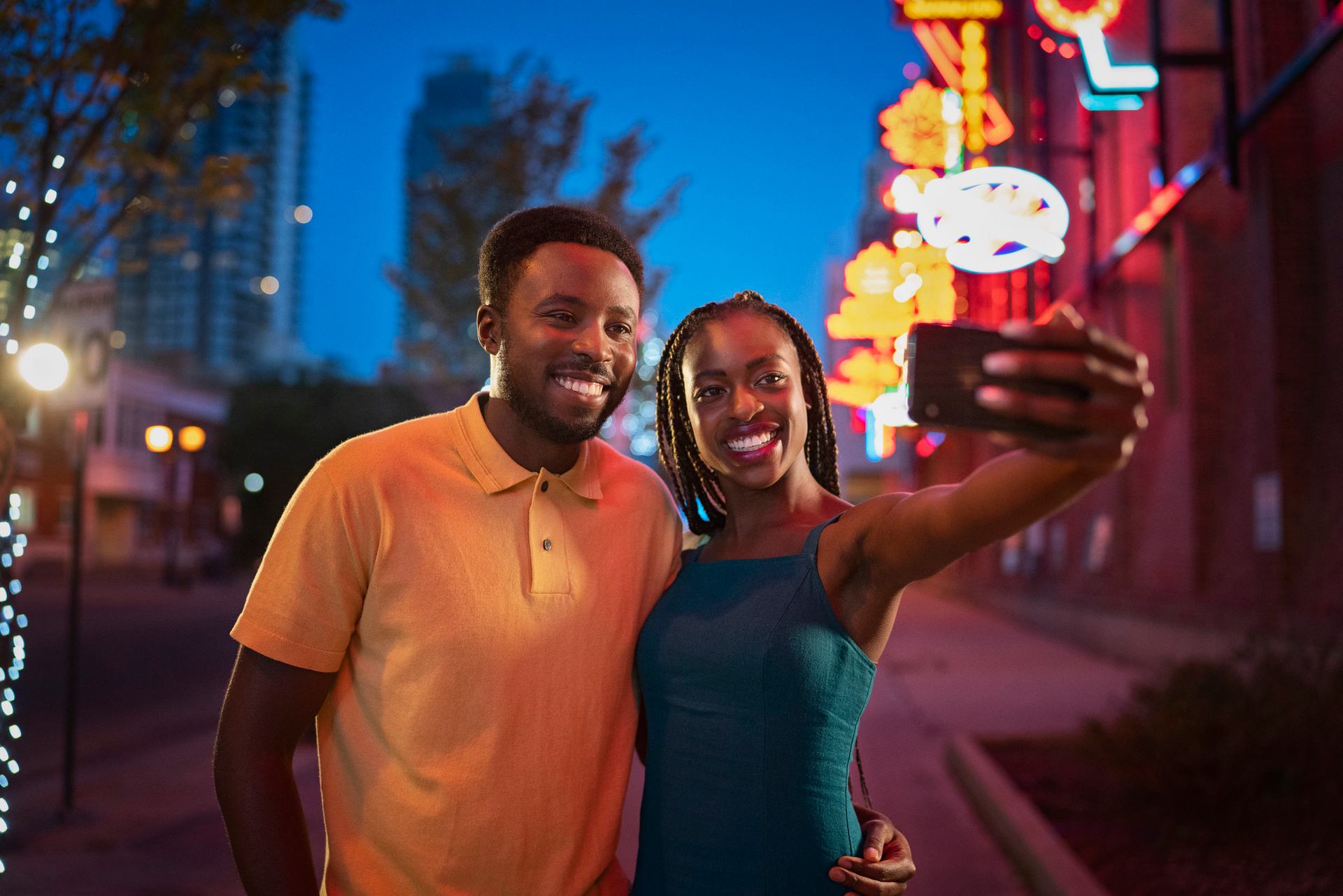 Couple taking a selfie in front of neon sign museum in Edmonton