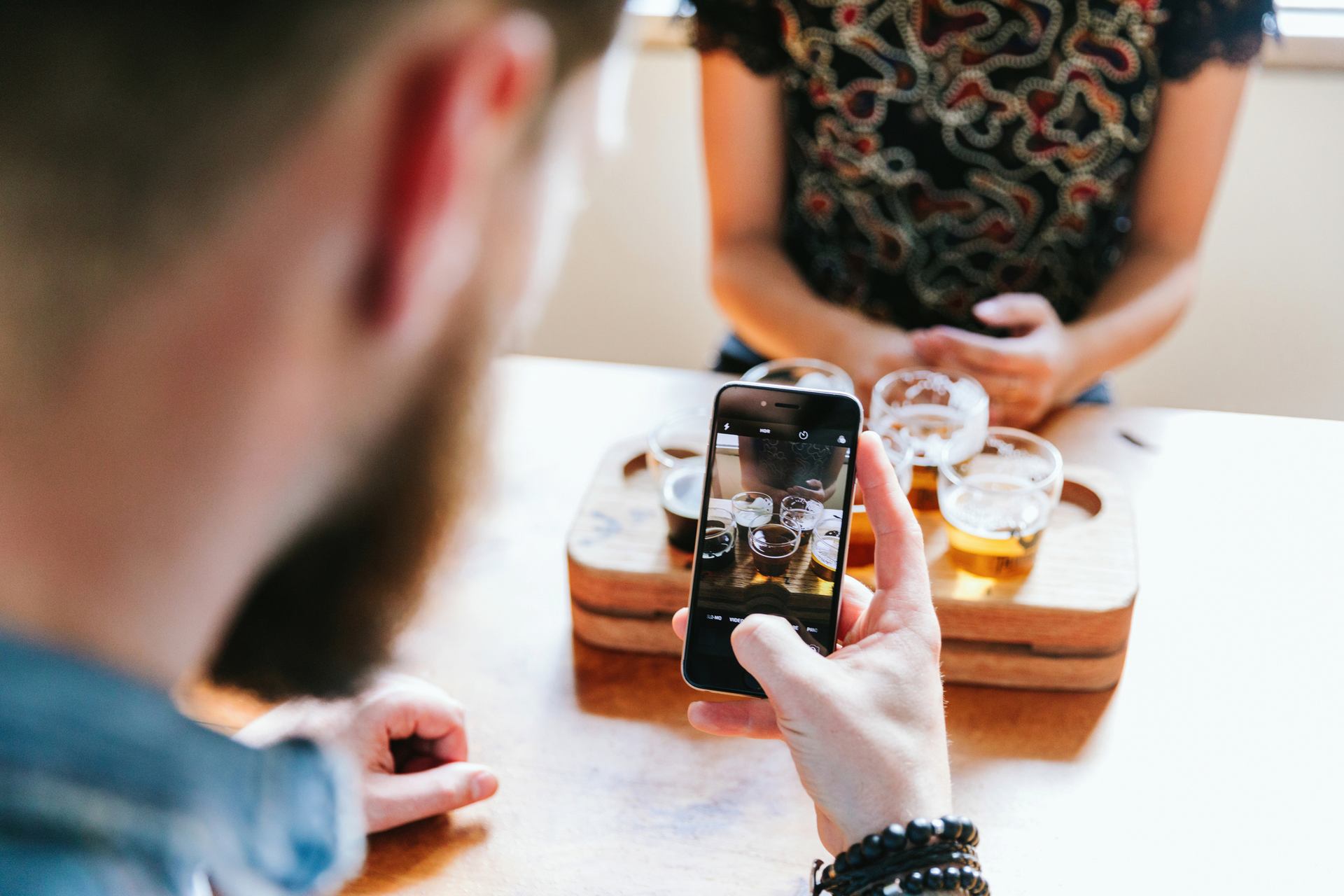 Man taking a photo of a beer flight