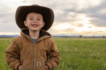 Young boy standing in a field in Alberta.