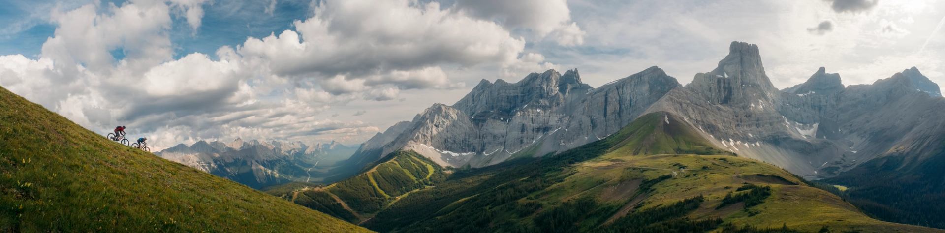 Two mountain bikers ride down a trail in Kananaskis Country