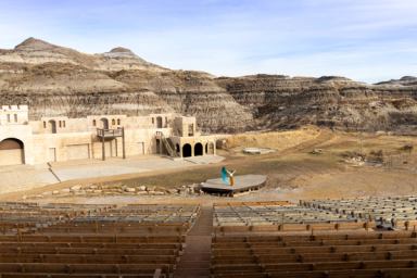 A dancer practices at the Badlands Amphitheatre with a permanent set and the canyons as a backdrop.