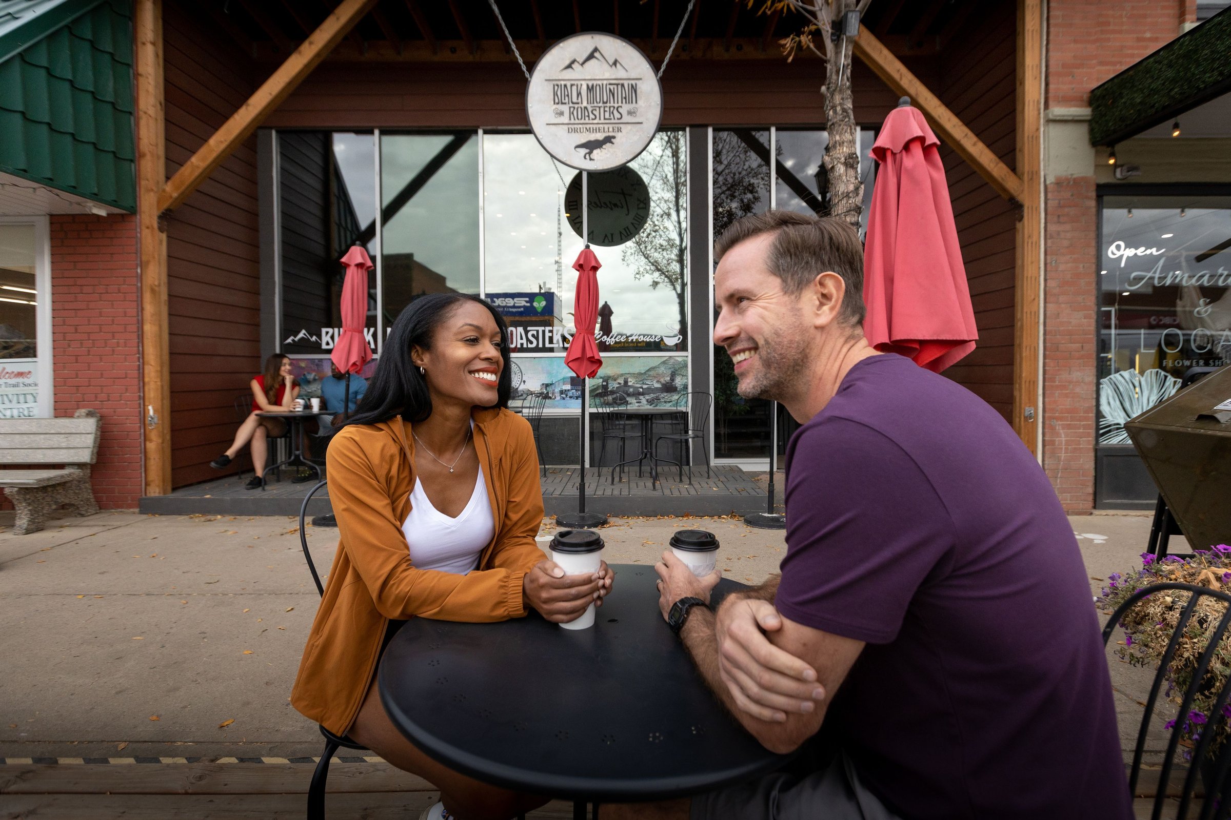 Couple drinking coffee outside Black Mountain Roasters coffee house.
