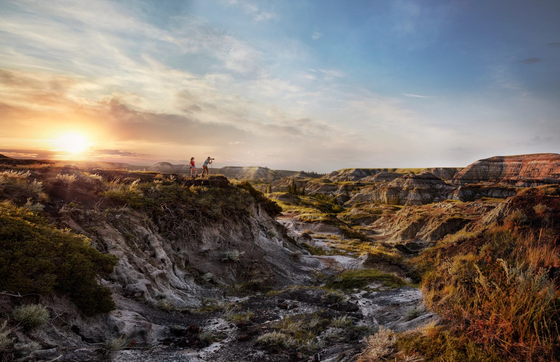 Couple taking photos as the sun goes down at Horseshoe Canyon near Drumheller.