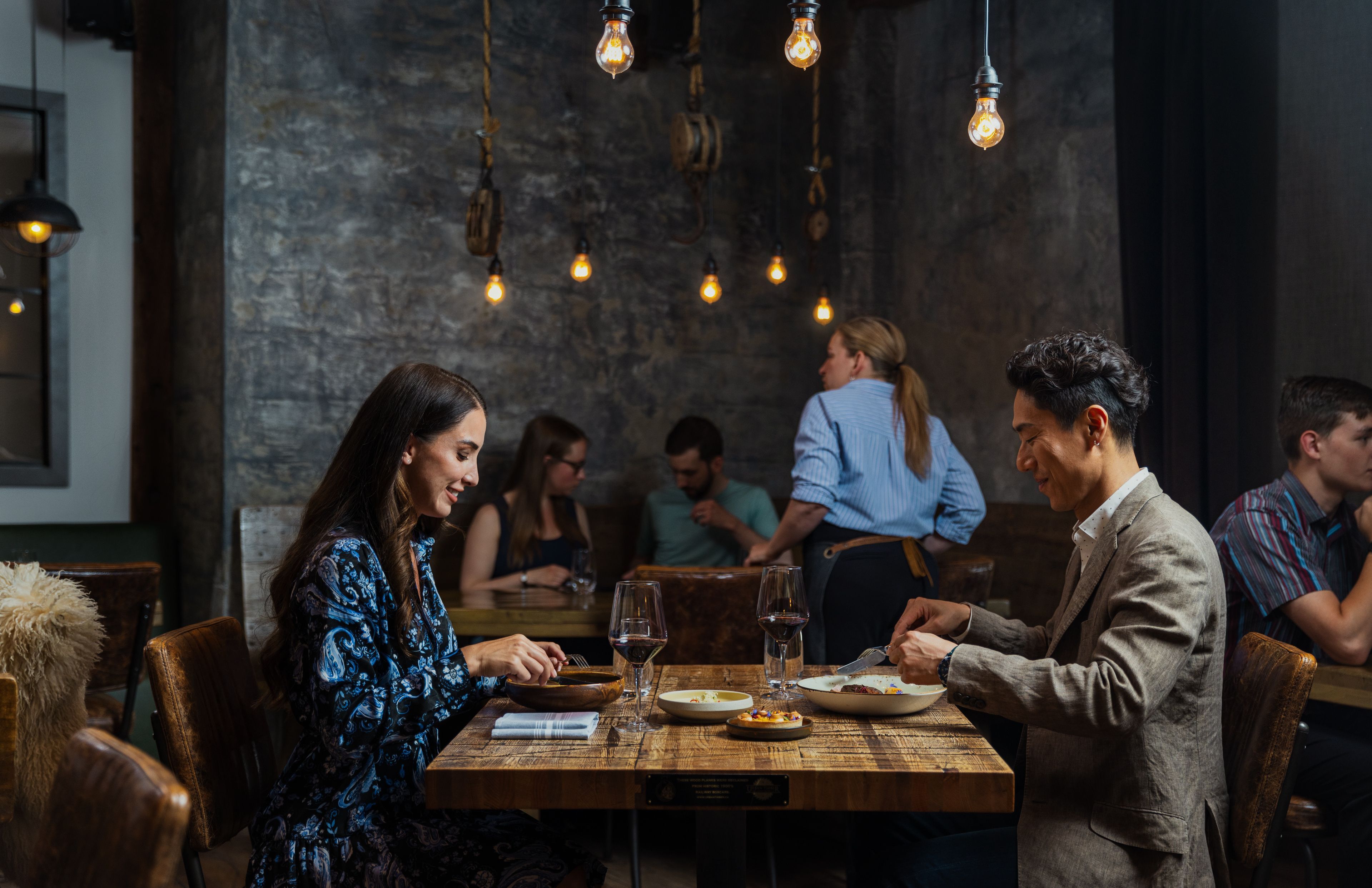 Two people eat dinner at a restaurant
