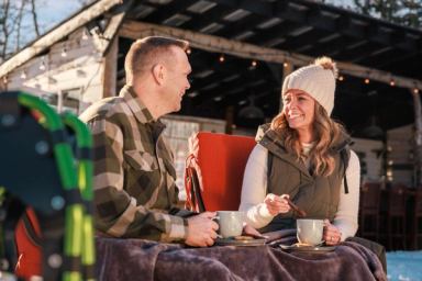 Couple enjoying hot chocolate outside at River Retreat Kananaskis.
