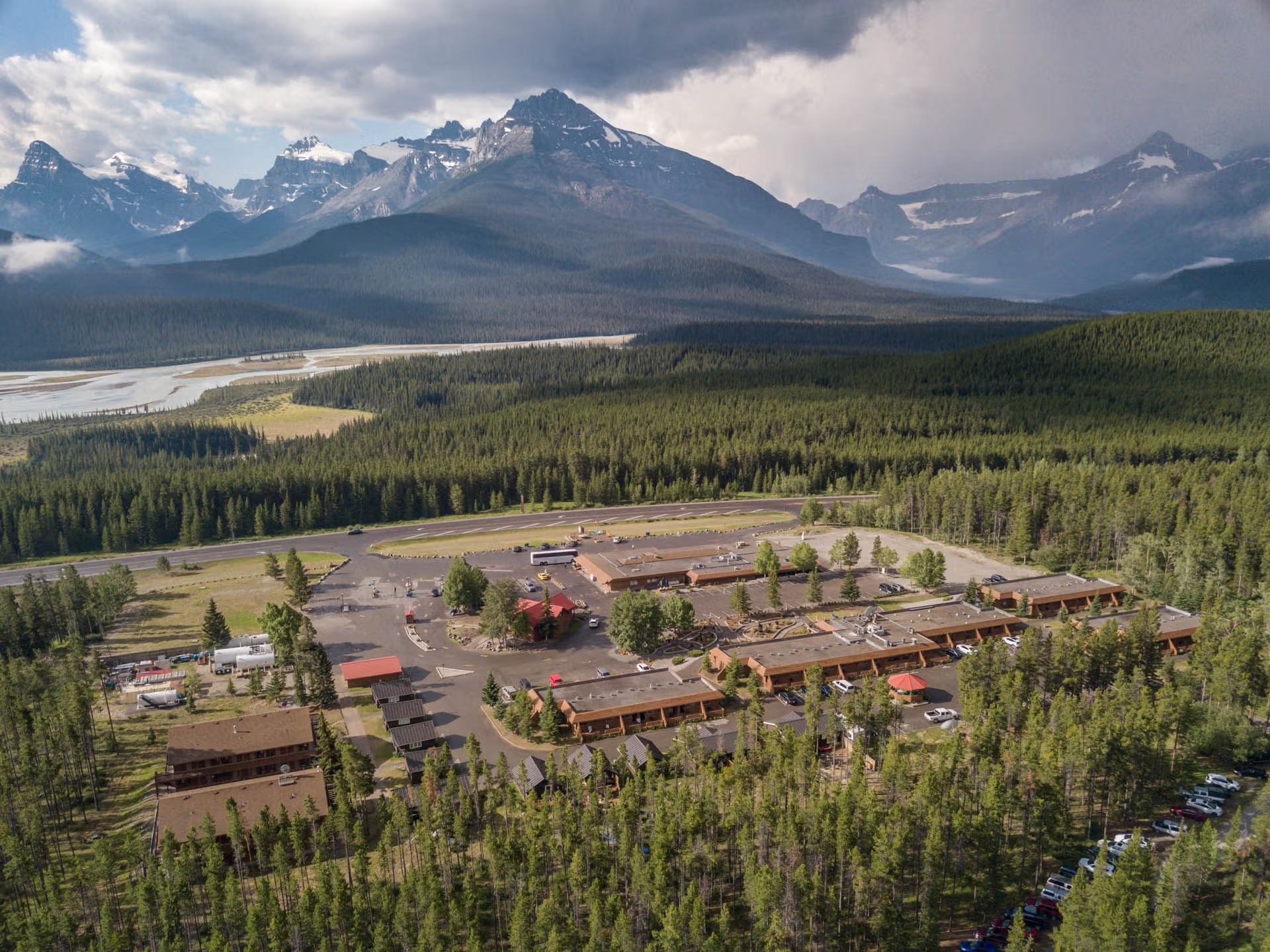 A bird's-eye view of the Crossing Resort along the Icefields Parkway, which is surrounded by boreal forest and the Rocky Mountains