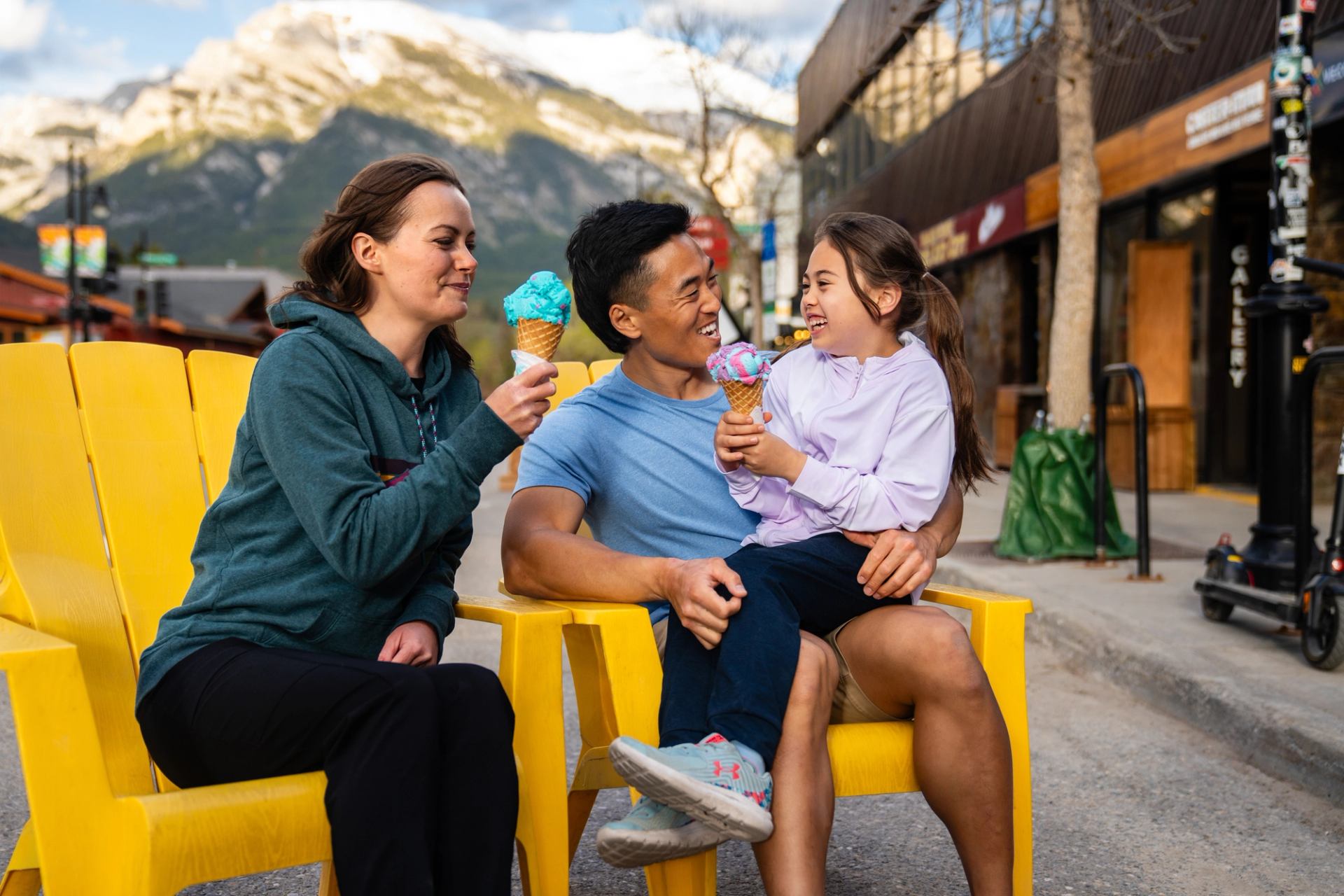 A family sits together in Downtown Canmore, enjoying ice cream together.