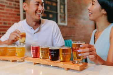 Couple enjoying a flight of beer at Travois Ale Works in Medicine Hat.