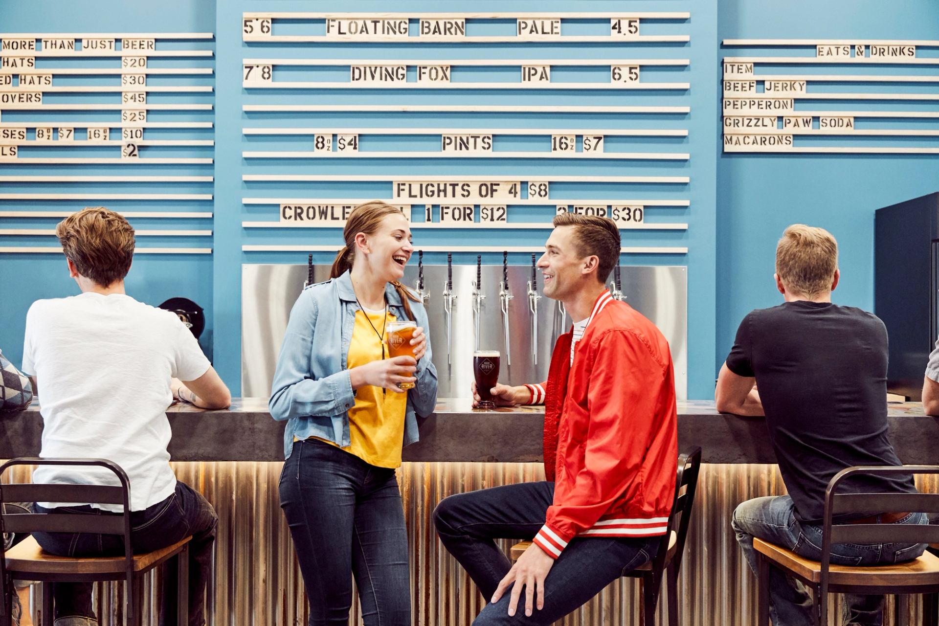 Couple standing at the bar enjoying a beer at the High River Brewing Company.