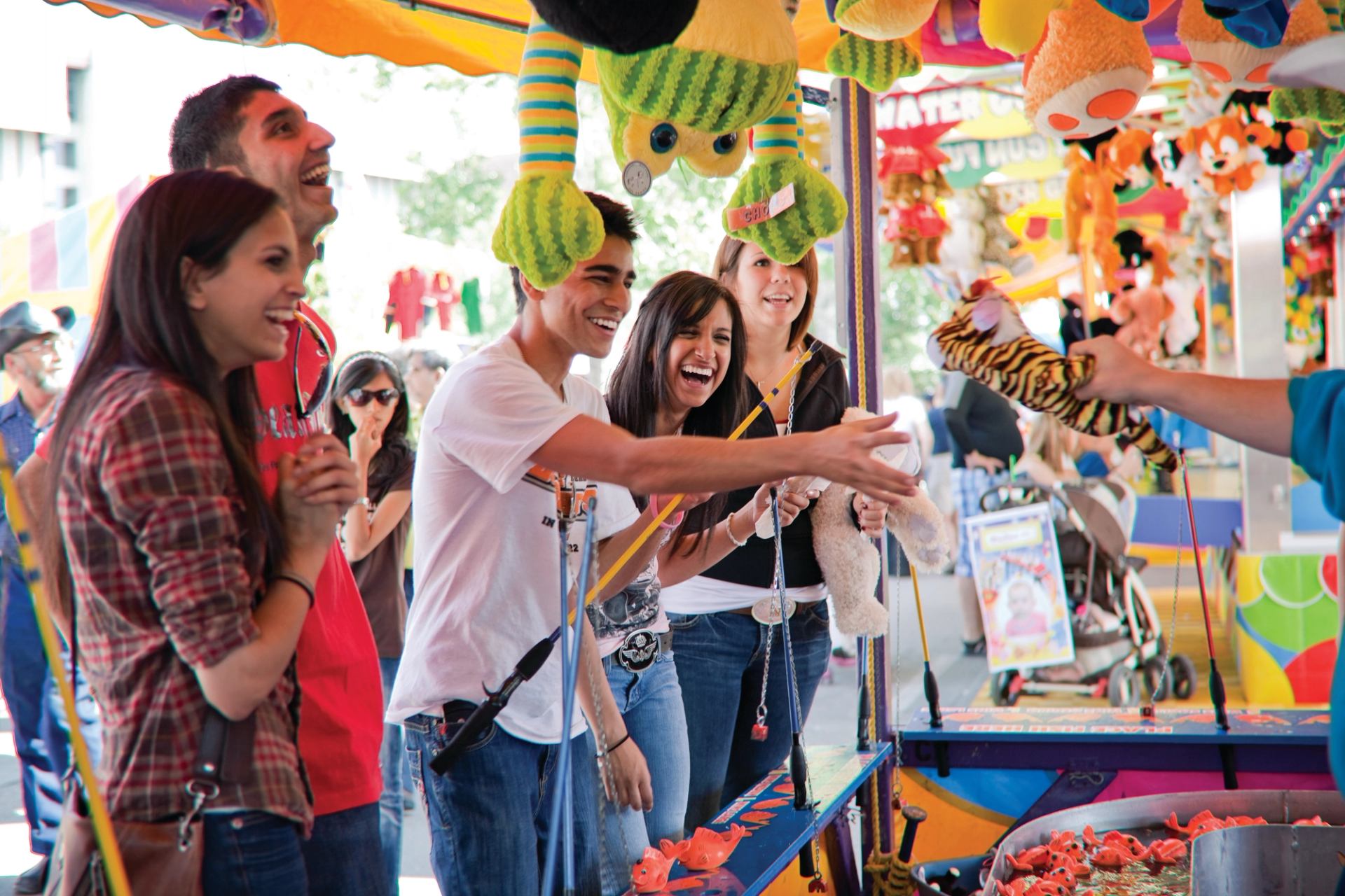 A group of friends playing carnival games at the Calgary Stampede.