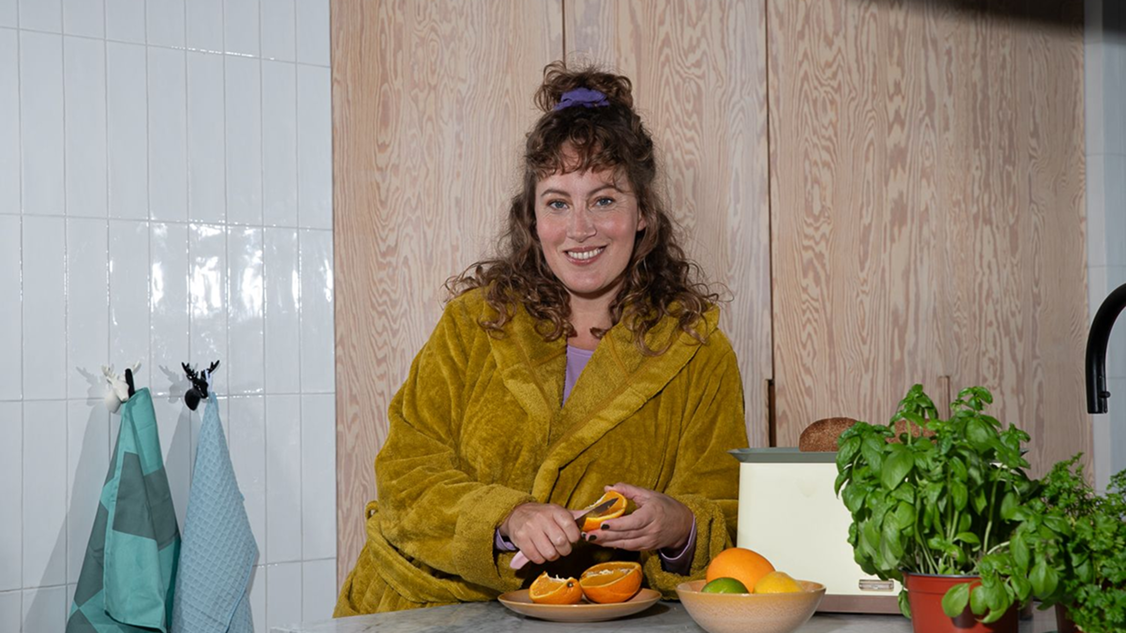 Vrouw schilt sinaasappel in keuken, symbool voor controle over energie en duidelijkheid