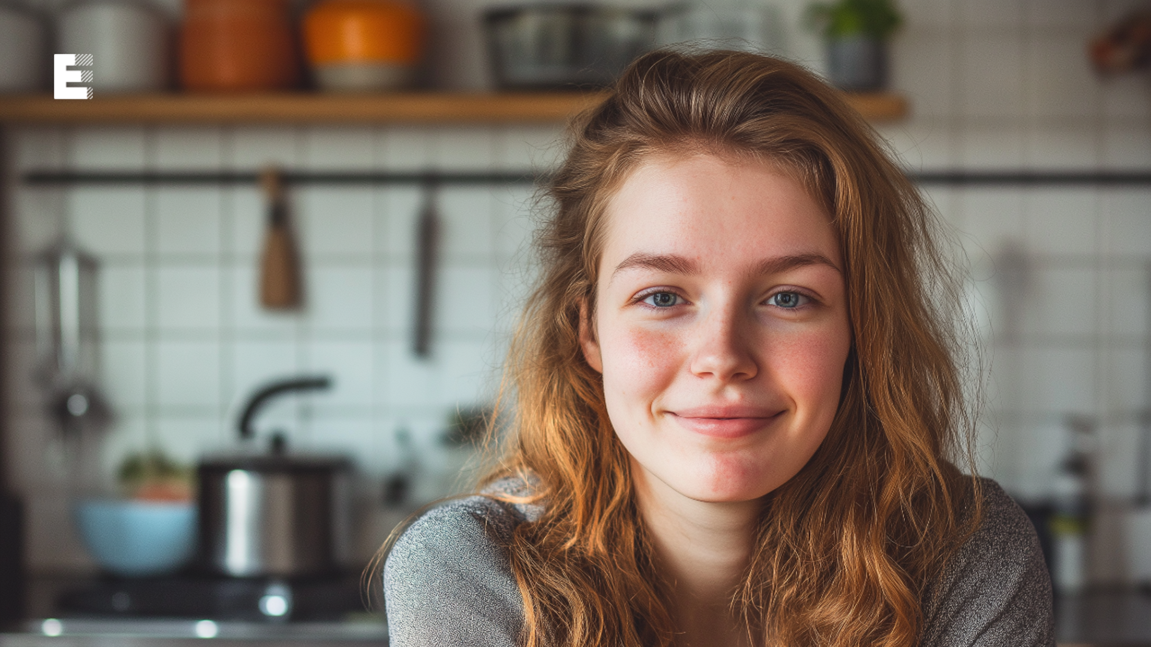 Jonge vrouw die met zelfvertrouwen lacht naar de camera. Warmte straalt van haar af.