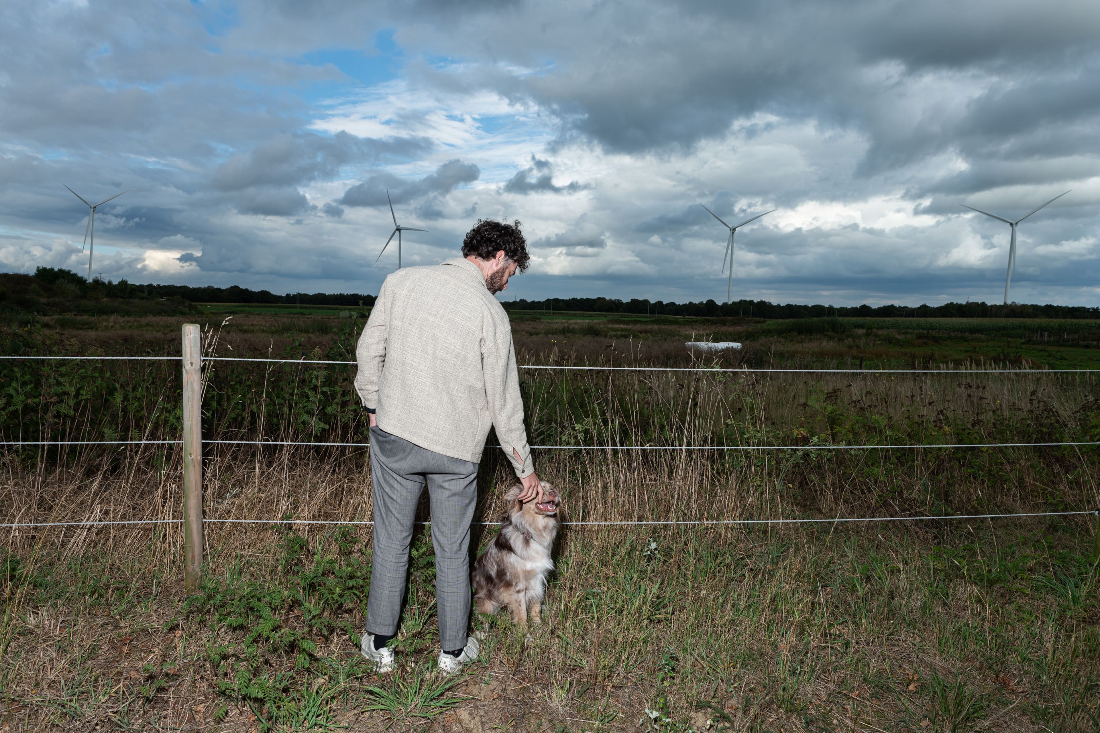 Een hond met zijn baasje in een natuurlijke omgeving, symbool voor lokale energie dicht bij ons