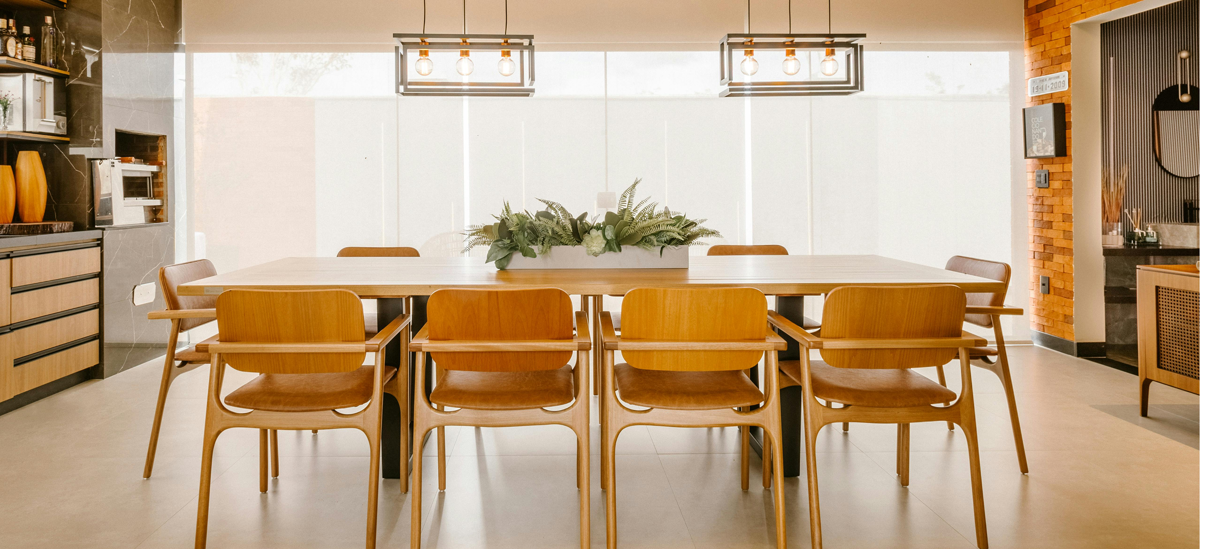 "Contemporary dining room with solid wood table, crafted timber chairs, industrial pendant lighting, and timber ceiling"