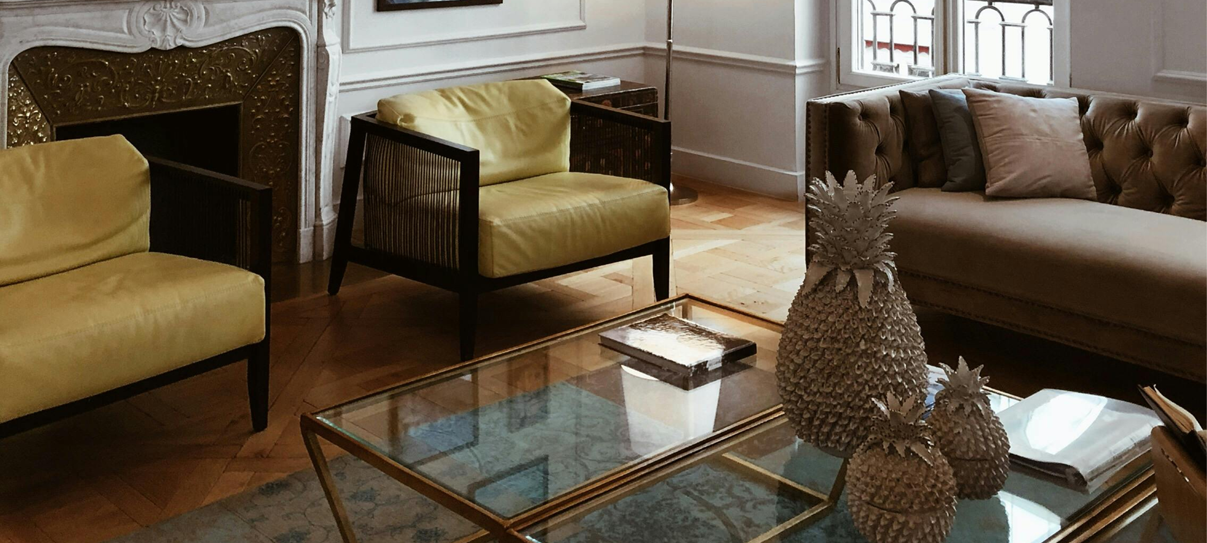 Elegant residential living room with woven pendant light, classic fireplace, gallery wall, and curated furnishings