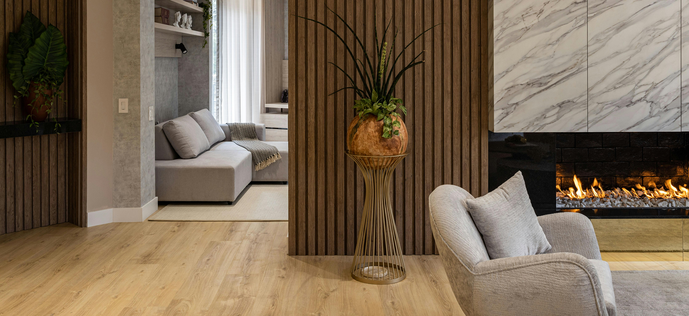 "Modern luxury living room by Inhouse Design Studio featuring wood slat walls, marble fireplace, and bespoke furniture."