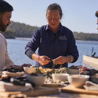 Group sharing oysters outdoors by the water, as part of The Merrimbula Merroir