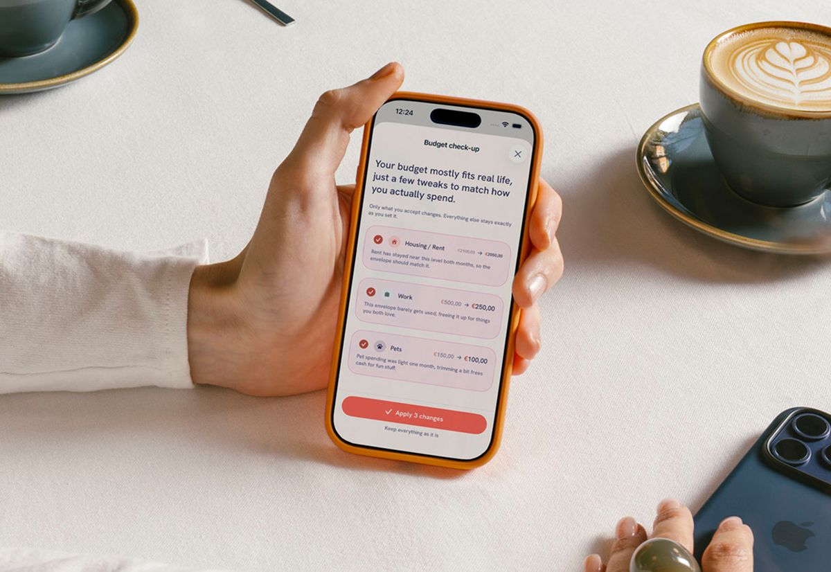A “Budget check-up” on a café table proposing three tweaks — rent, work and pets — above a button to apply all three or keep everything as it is.