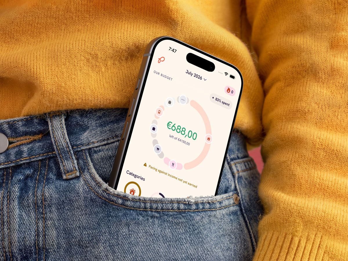A phone tucked into a front jeans pocket, the shared July budget on screen: €688,00 left of €4150,00.