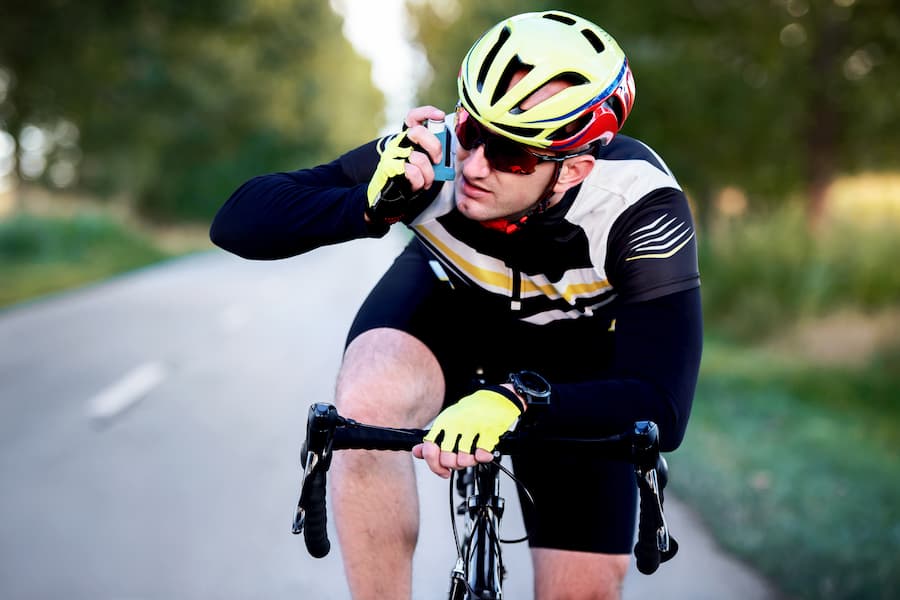 Man on bike using inhaler | The Allergy Group Idaho Inhaler Care