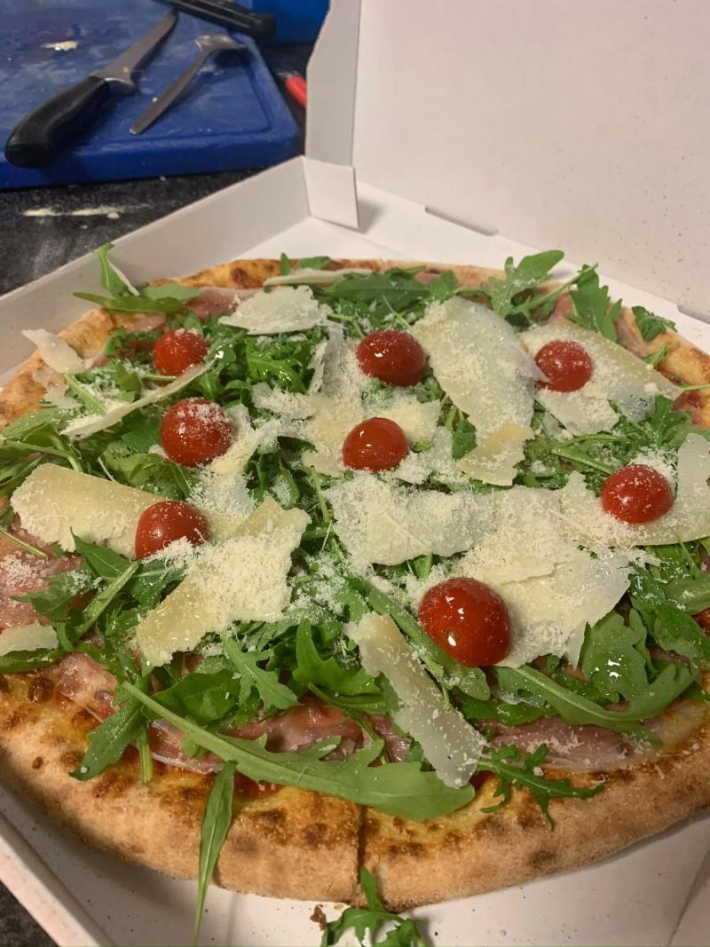 Pizza à la roquette, tomates cerises et copeaux de parmesan