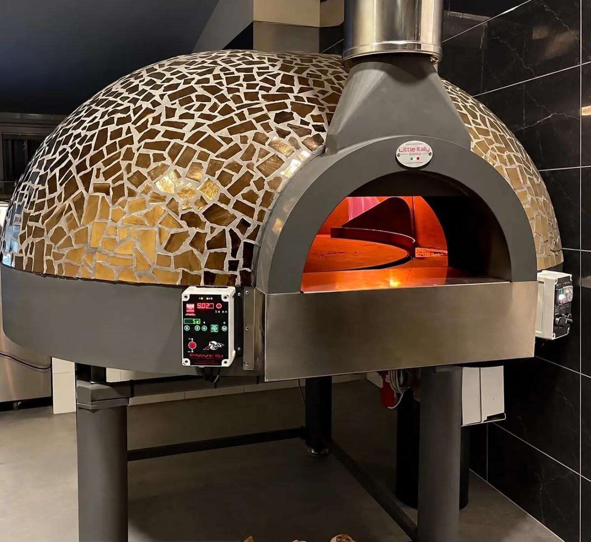 Le four à pizza en mosaïque dorée, allumé