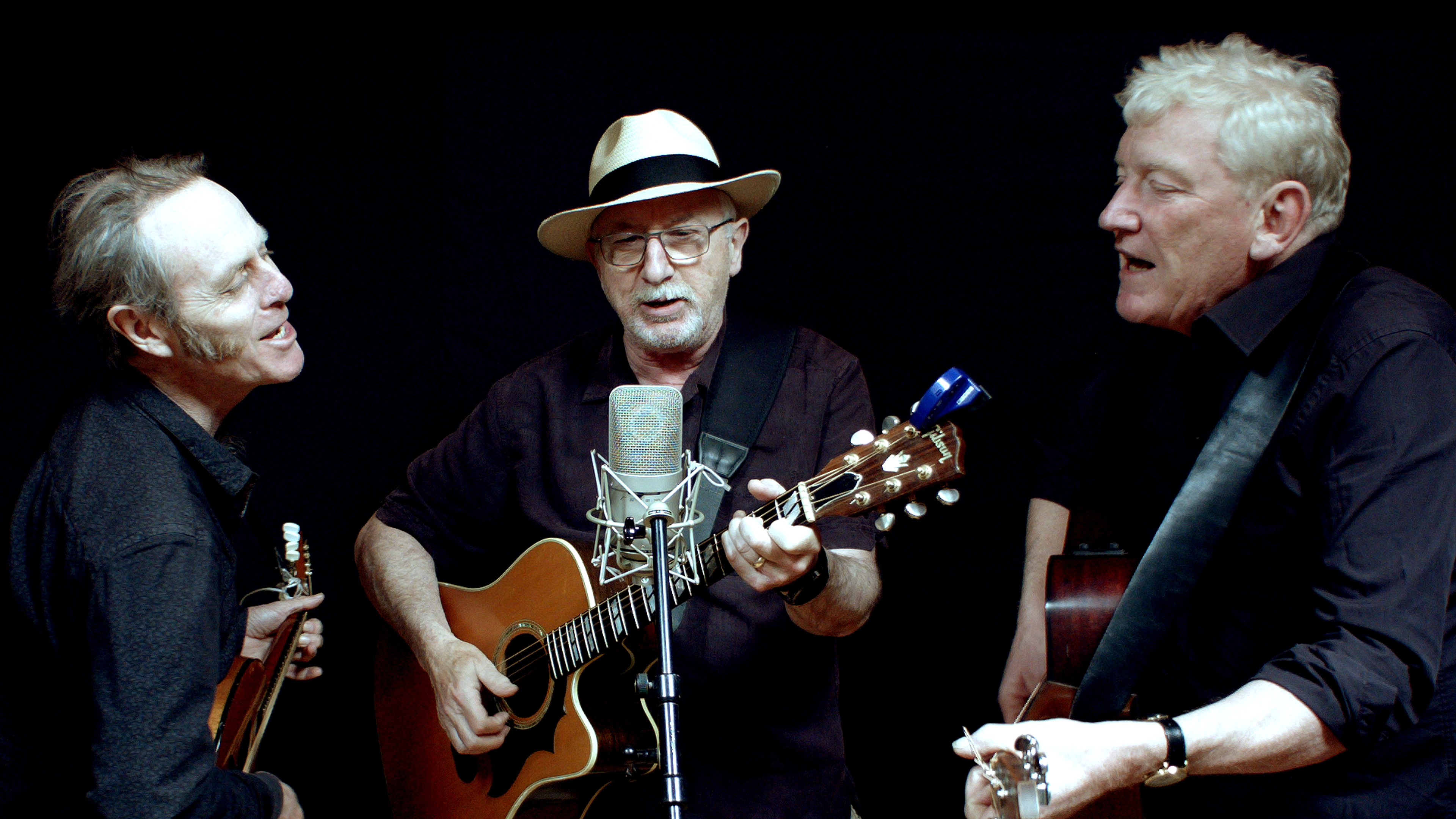 the three listeners singing into a mic