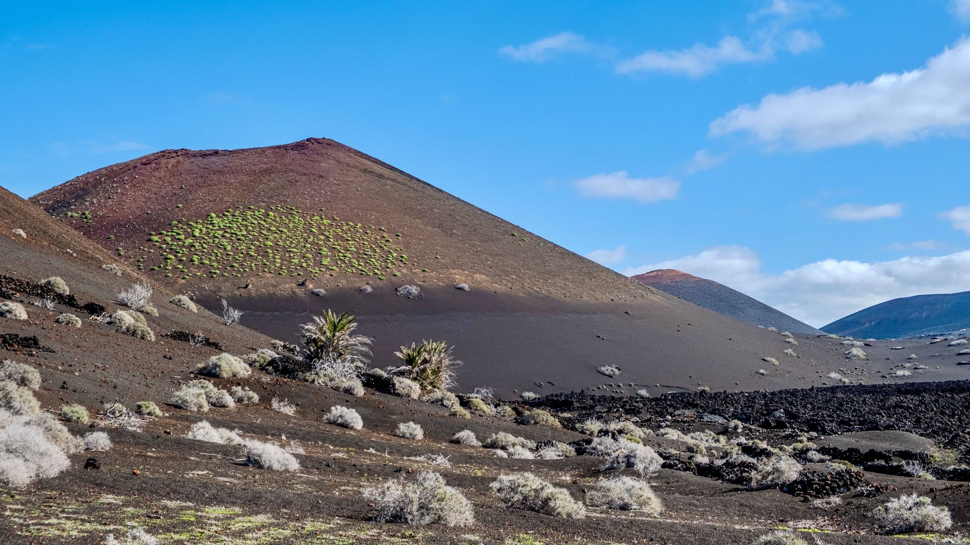 Volcanic cones and lava fields under a blue sky on Lanzarote