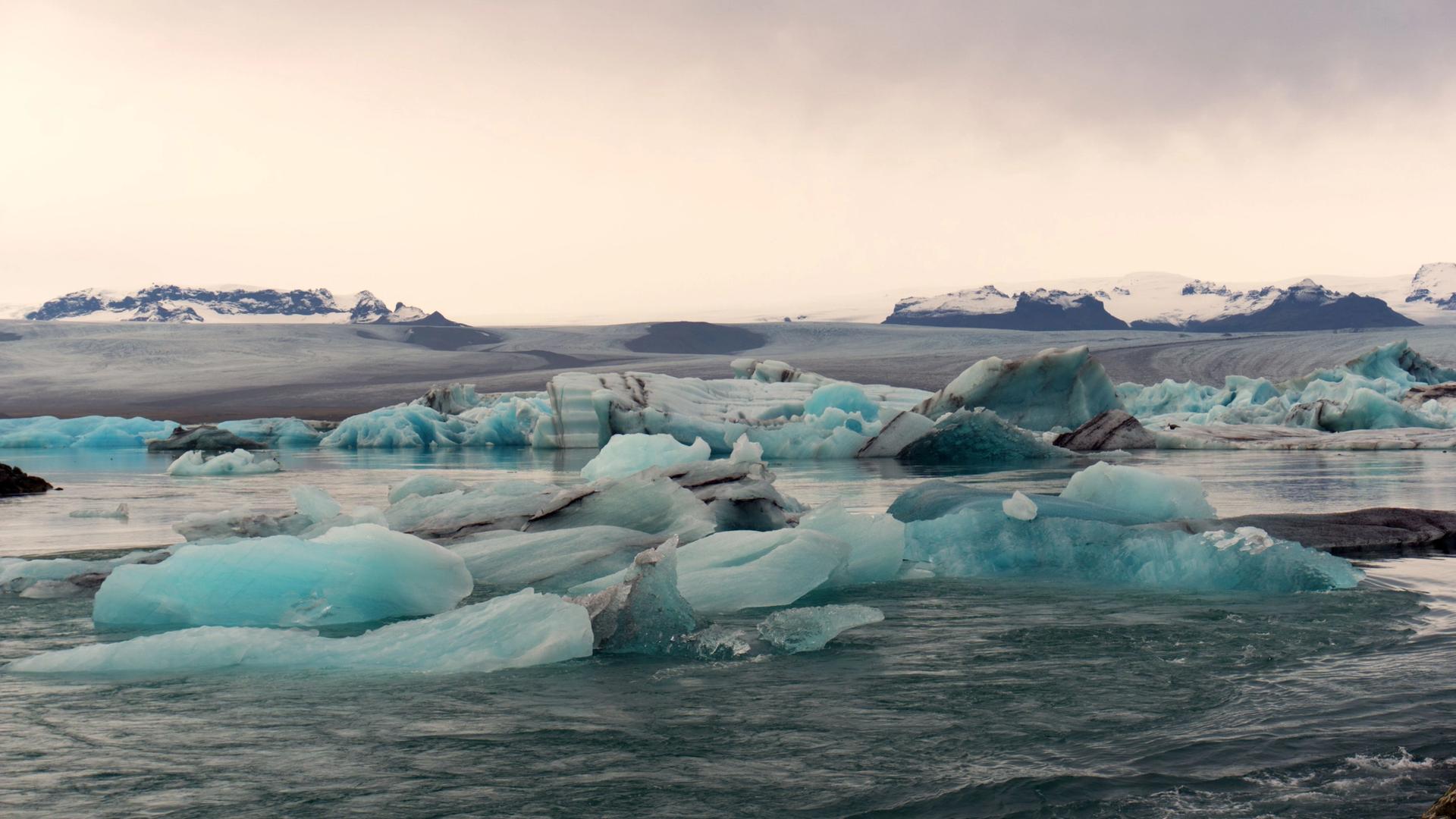 Icebergs floating on Jokulsarlon glacier lagoon under a grey sky