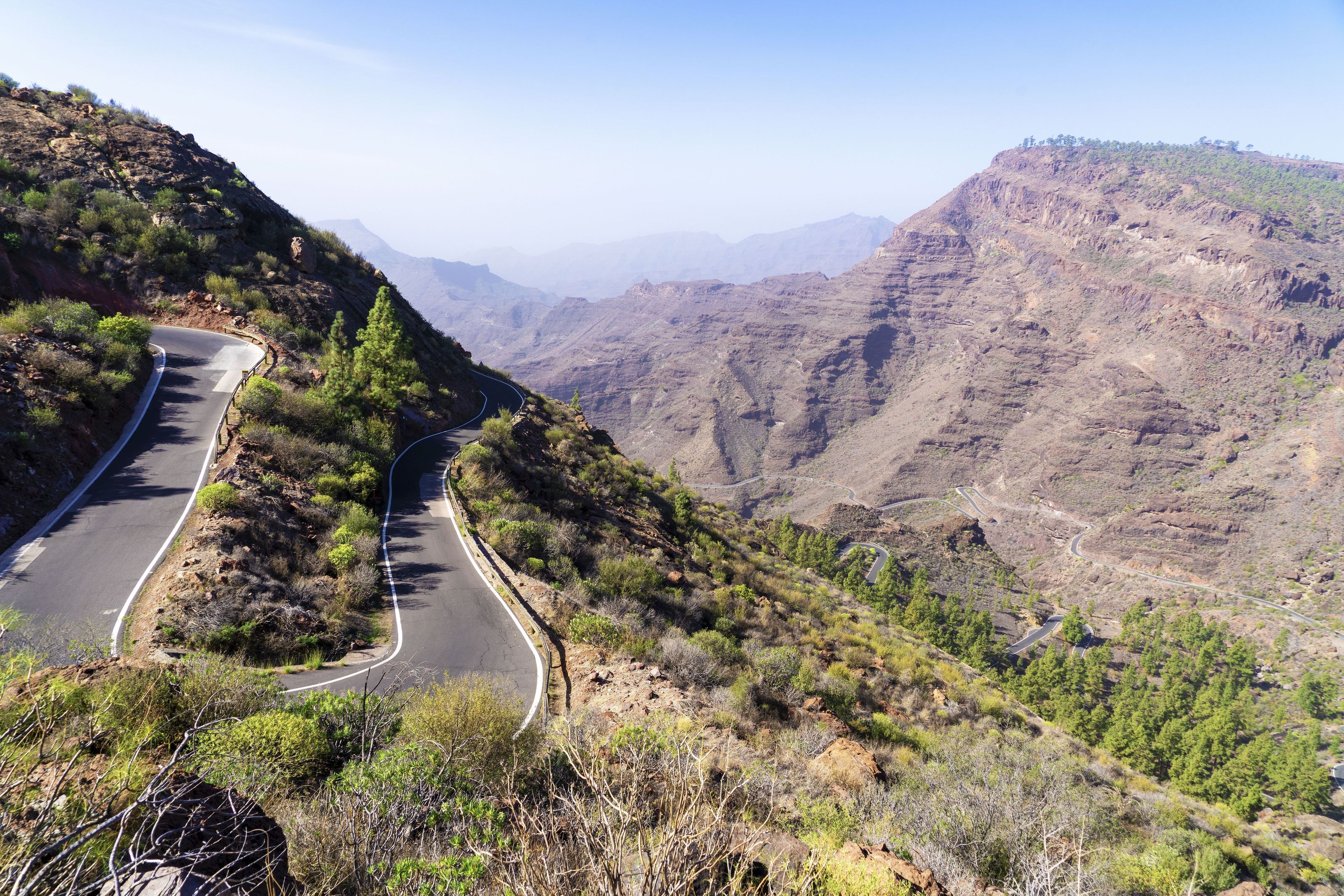 A winding mountain road on a green slope in the interior of Gran Canaria