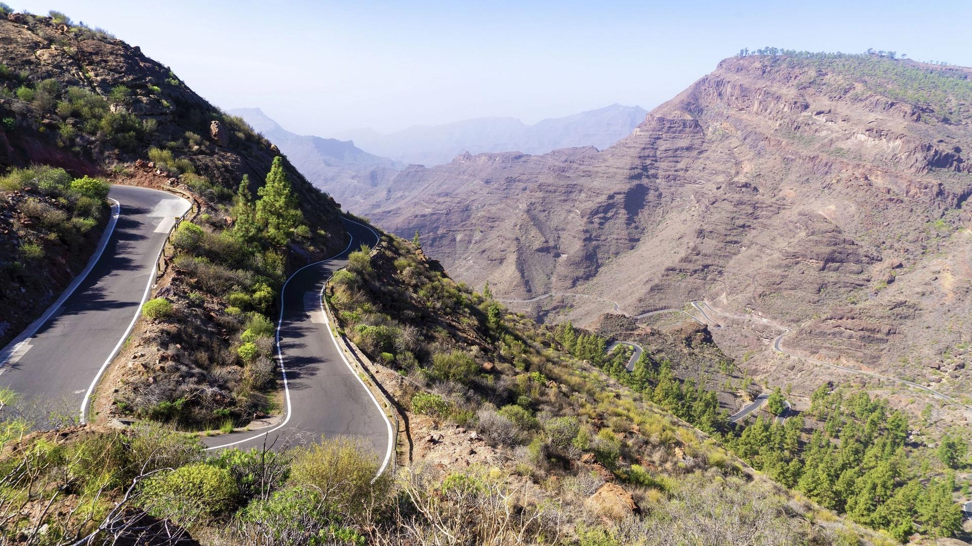 A winding mountain road on a green slope in the interior of Gran Canaria