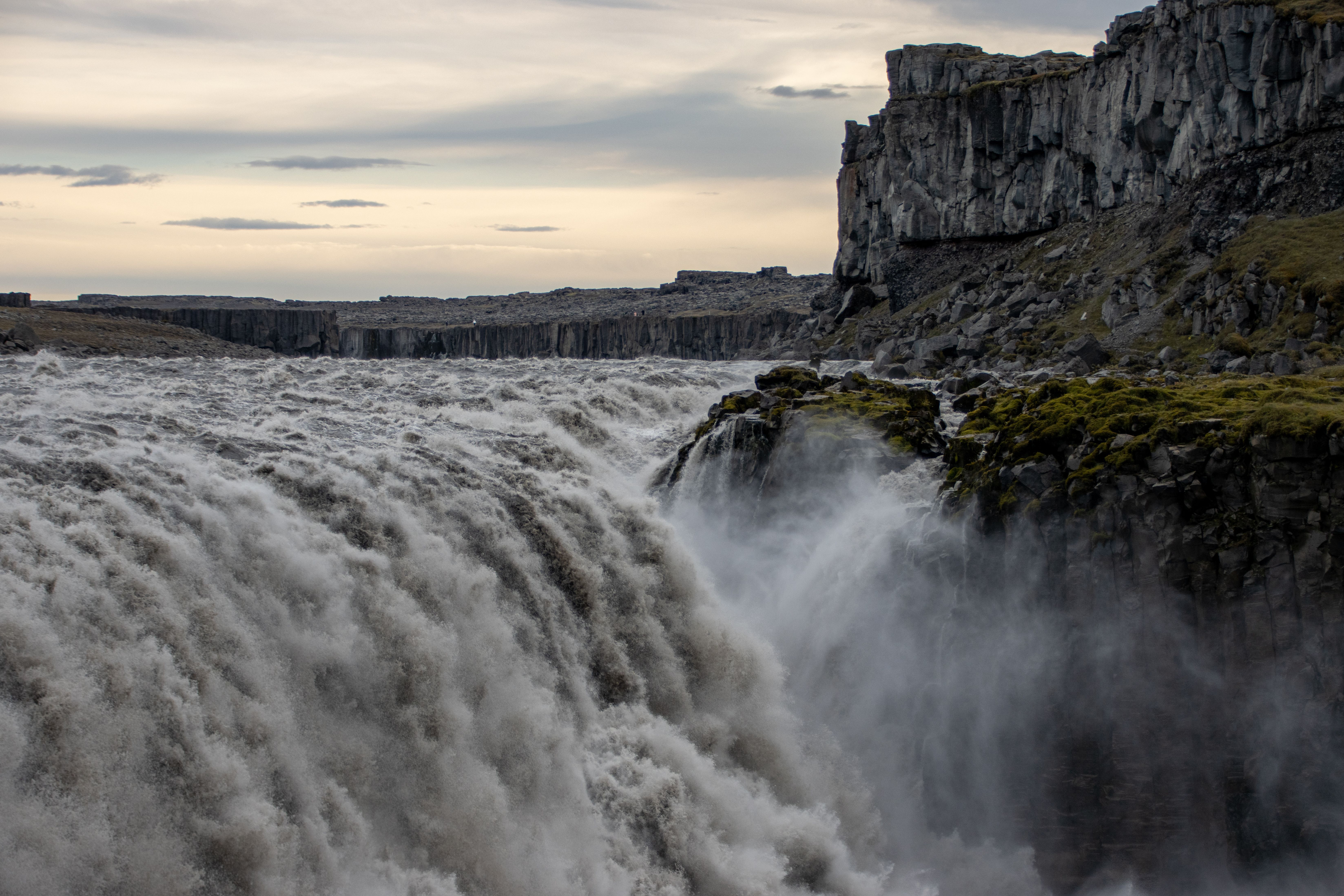 Massive Dettifoss waterfall throwing up spray in a river canyon