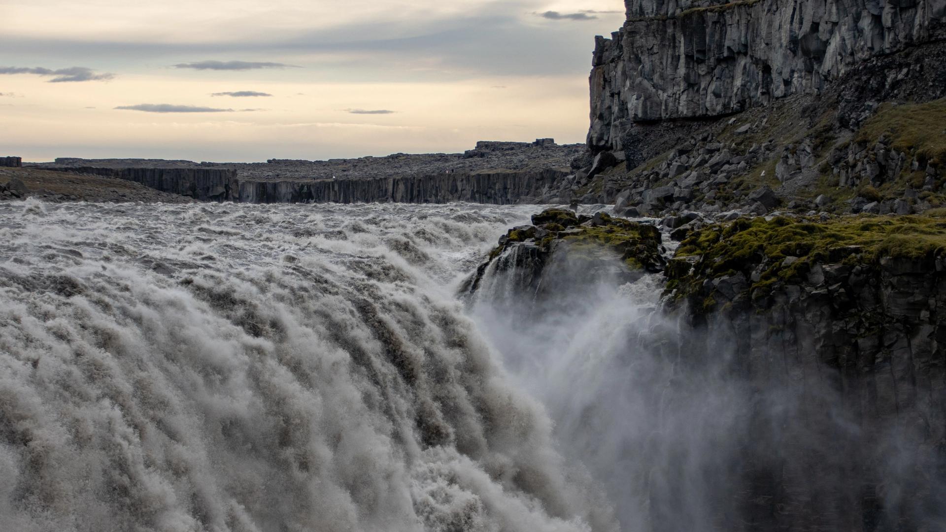 Massive Dettifoss waterfall throwing up spray in a river canyon
