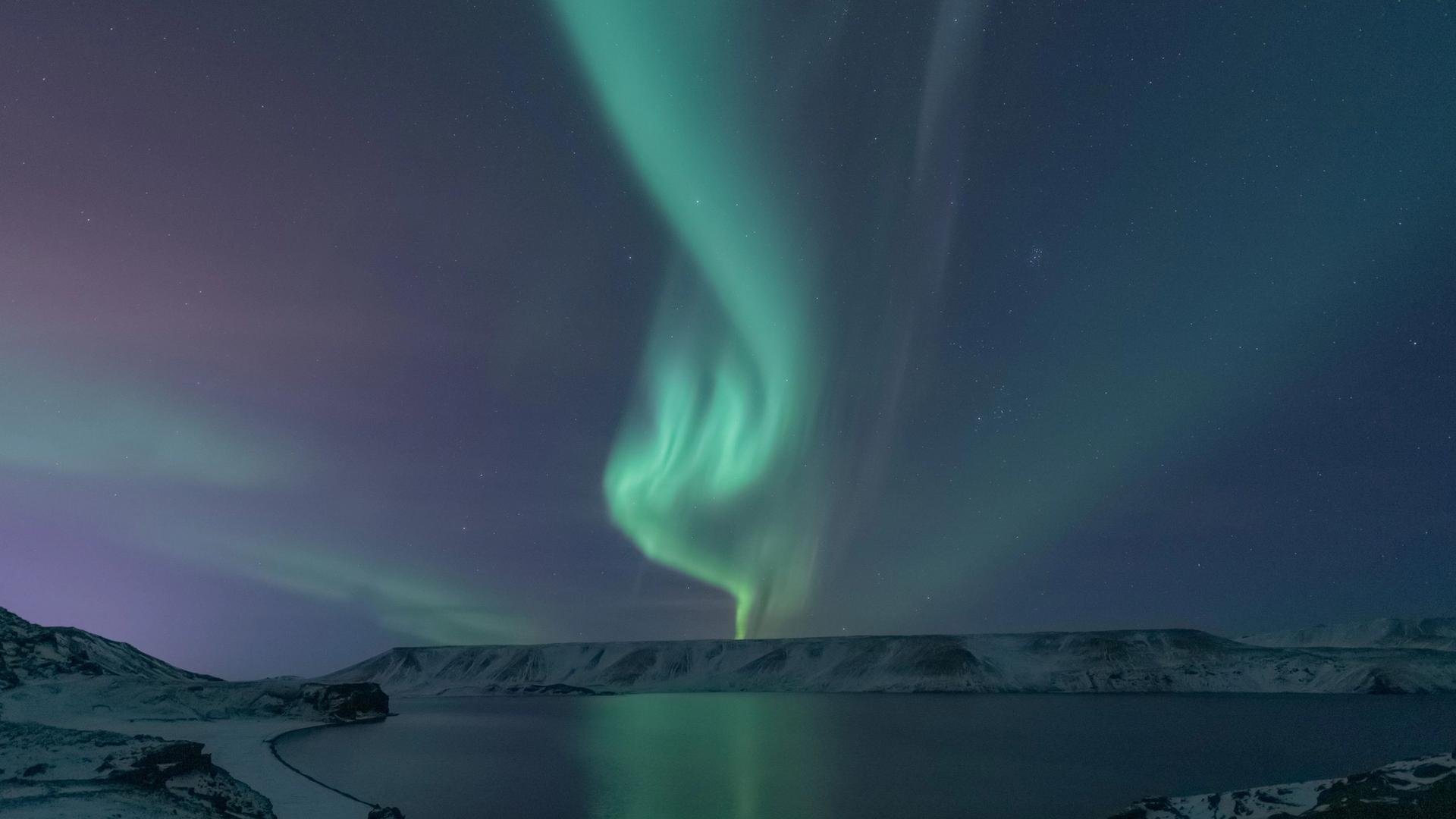 Northern lights over a snowy lake in Iceland