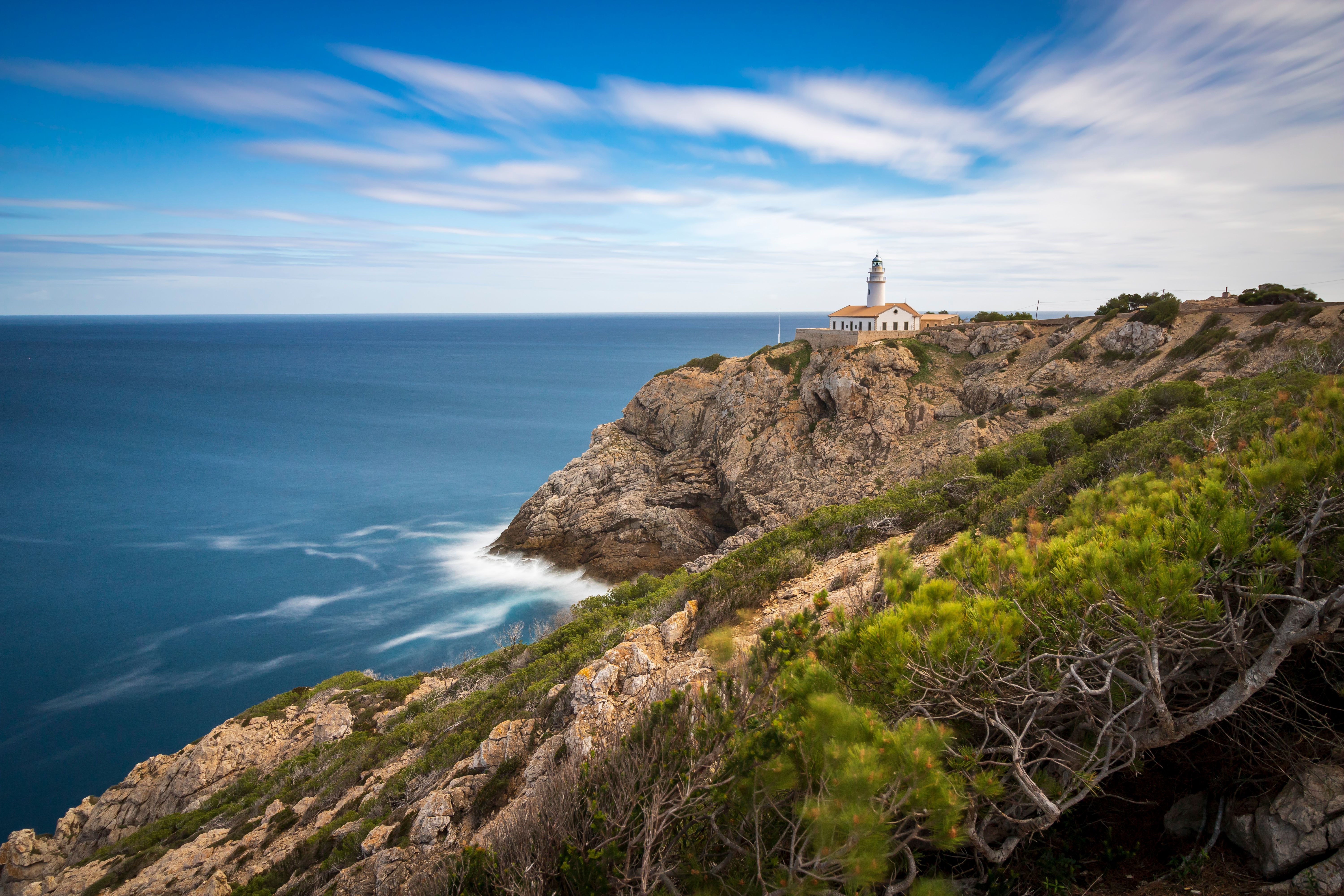 Rocky coastline of Cap de Creus with the lighthouse in the distance