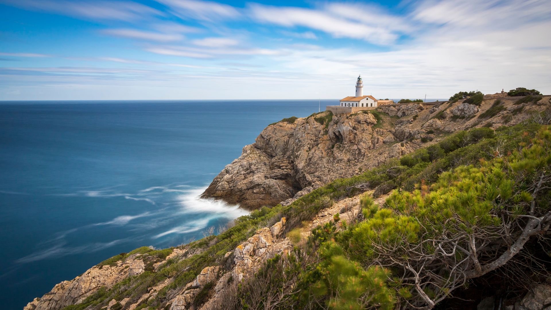 Rocky coastline of Cap de Creus with the lighthouse in the distance