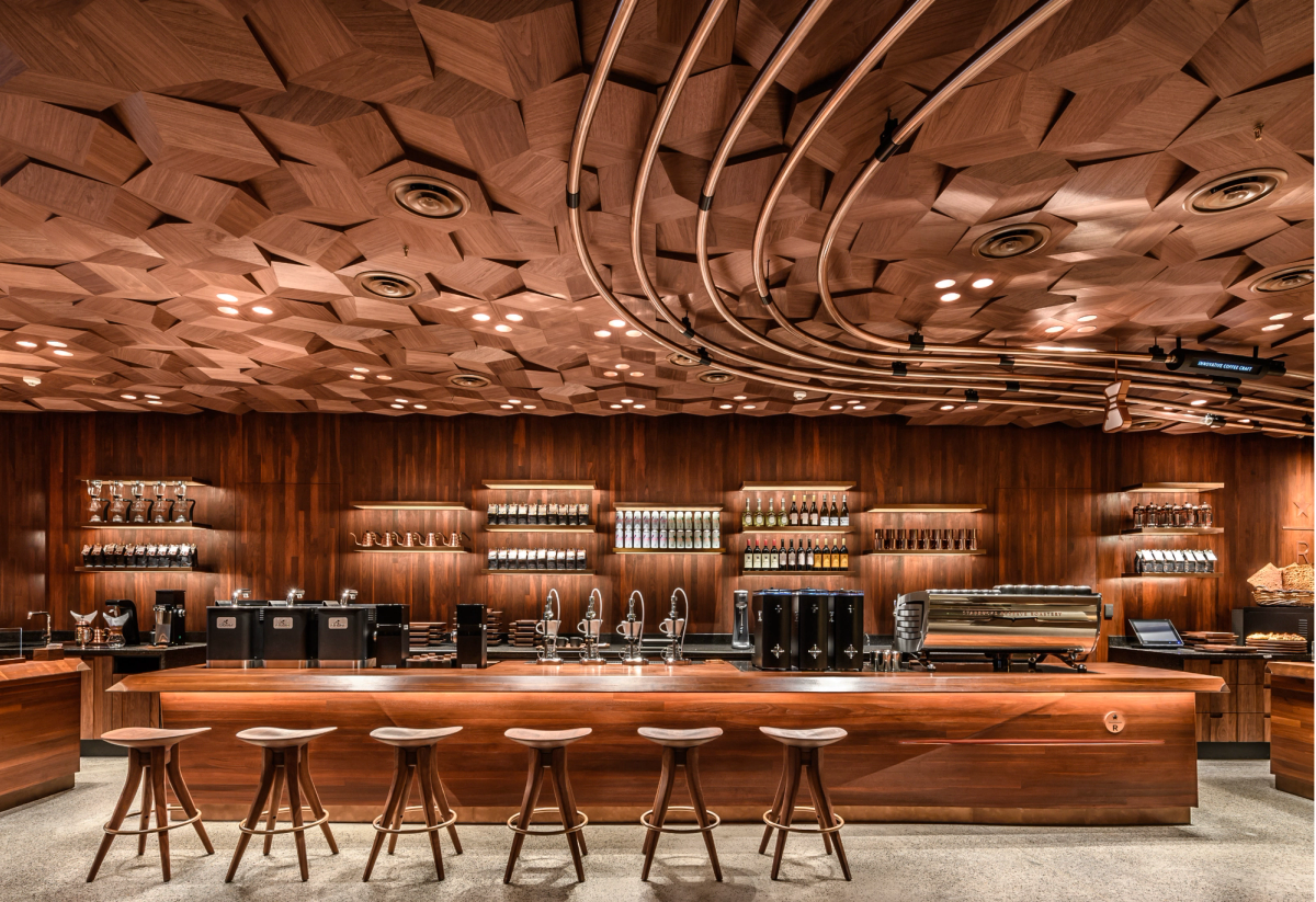 View inside Starbucks Reserve Roastery featuring wooden furniture, wooden acoustics ceiling and large bar