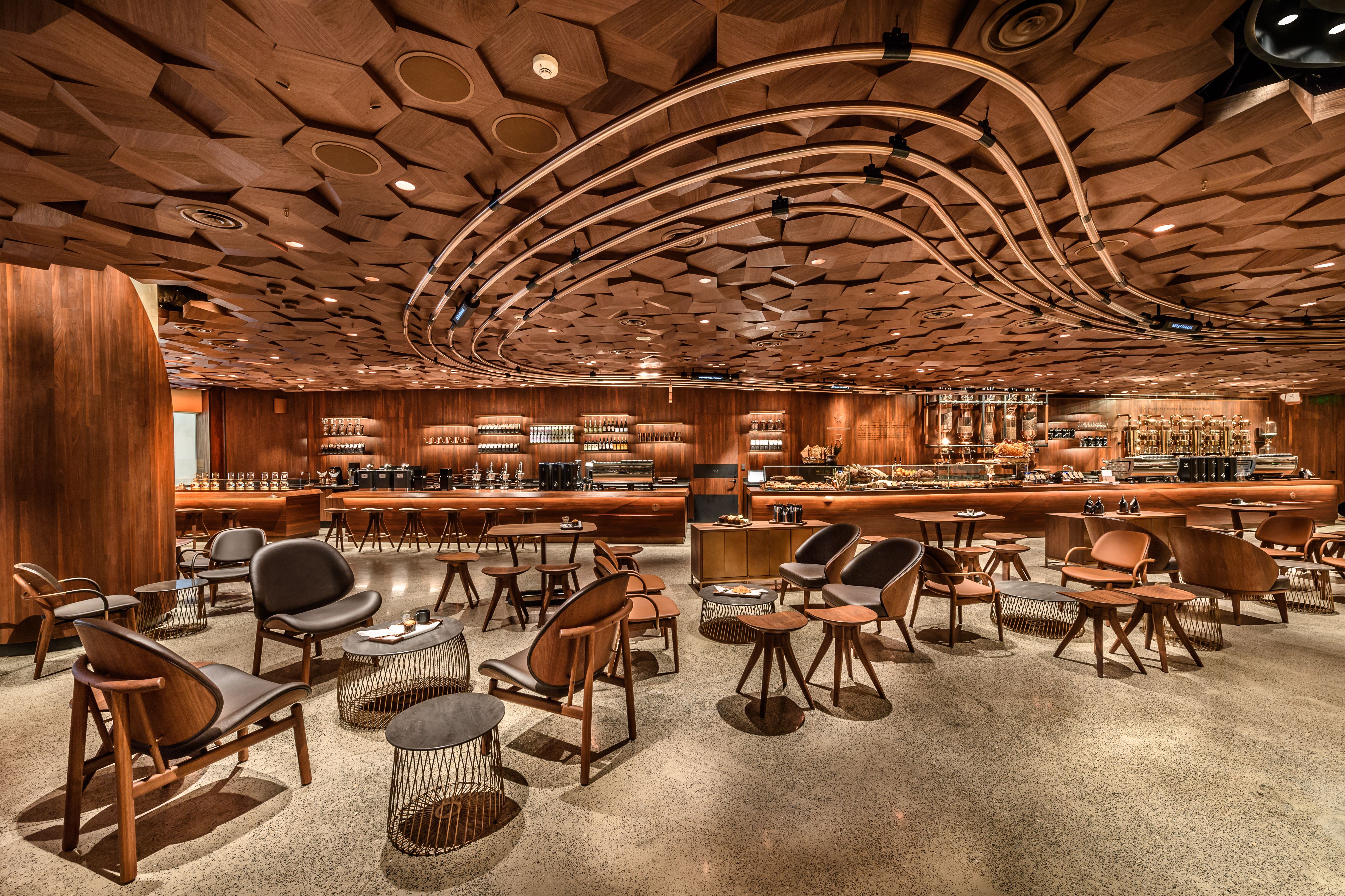 View inside Starbucks Reserve Roastery featuring wooden furniture, wooden acoustics ceiling and large bar