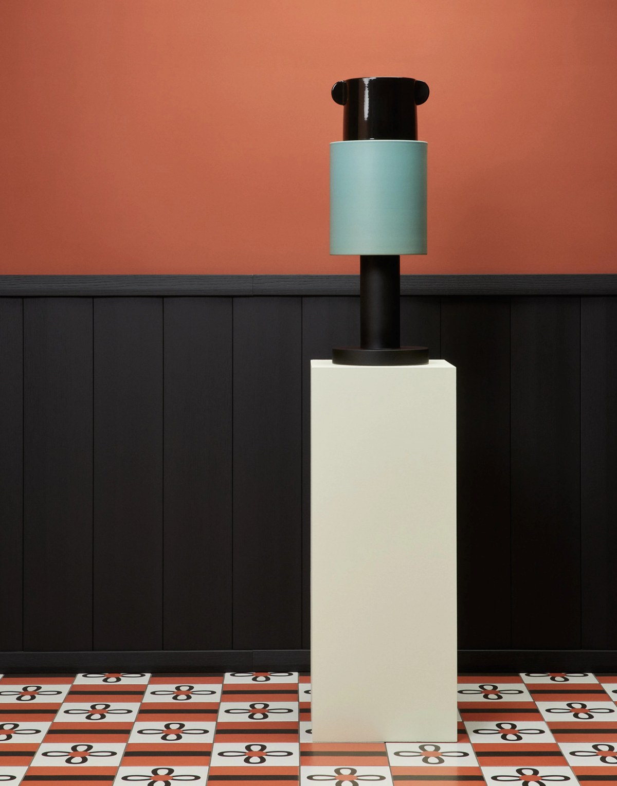 High ceramic art piece on tiled on black, white and red background