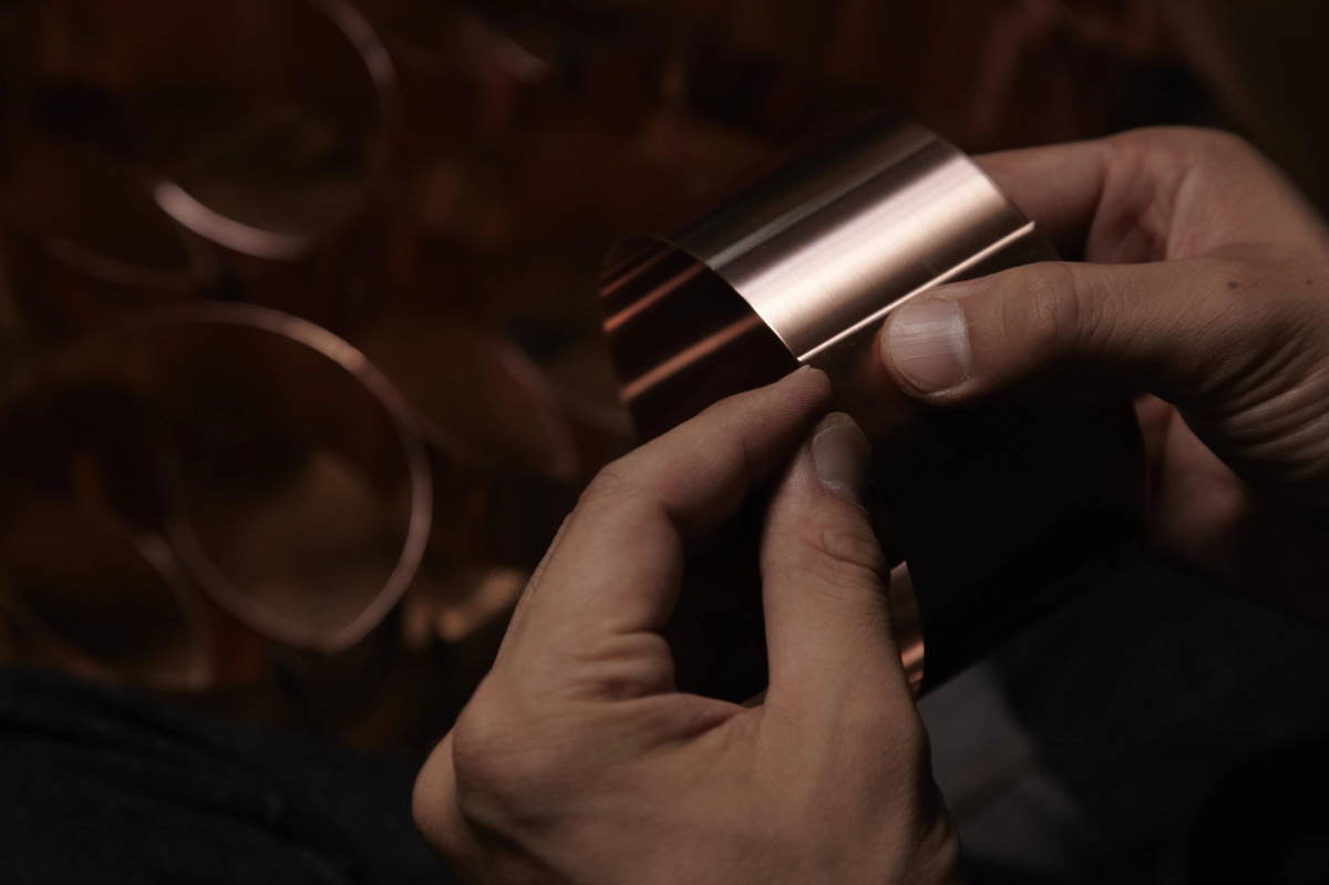 Hands holding a piece of copper 