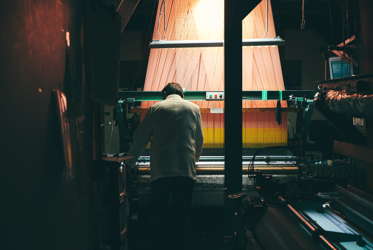 A man in front of a traditionally Japanese Nishijin loom