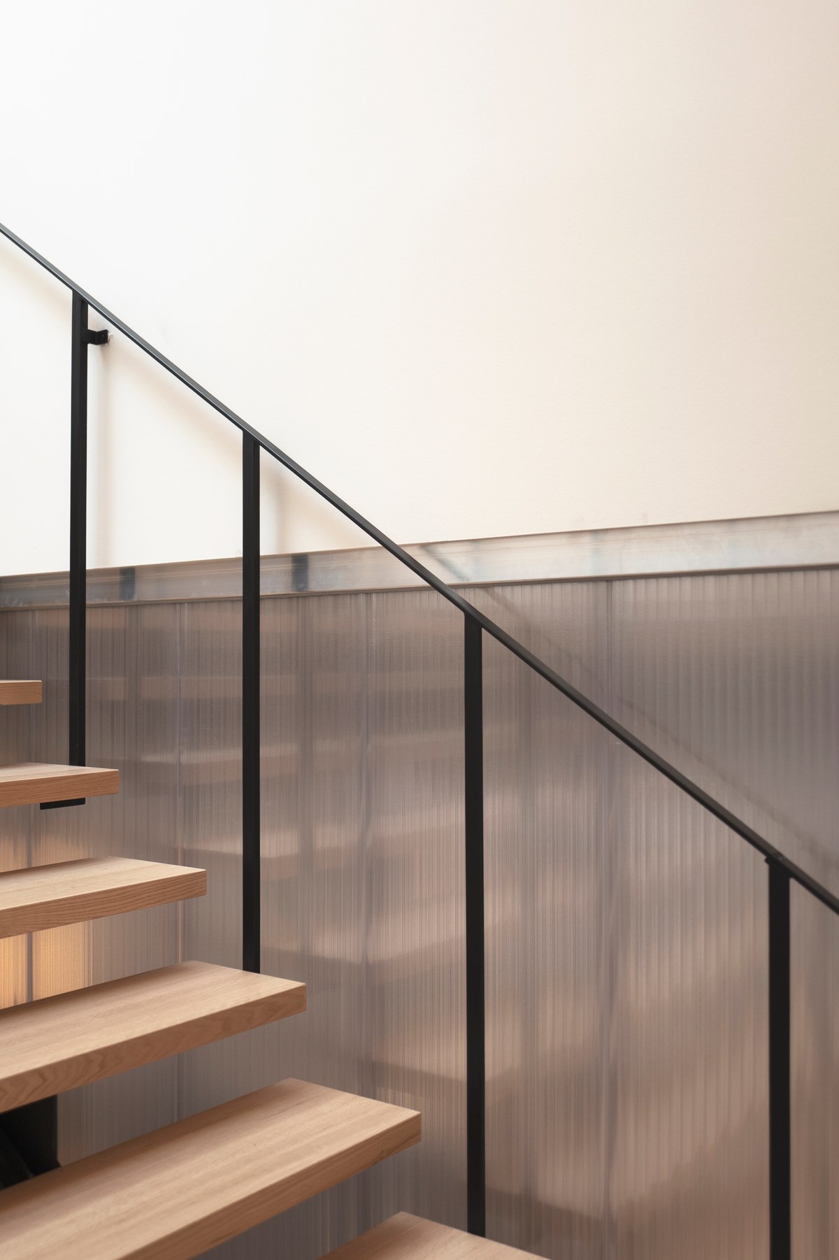 Wooden staircase with black metal hand rail 