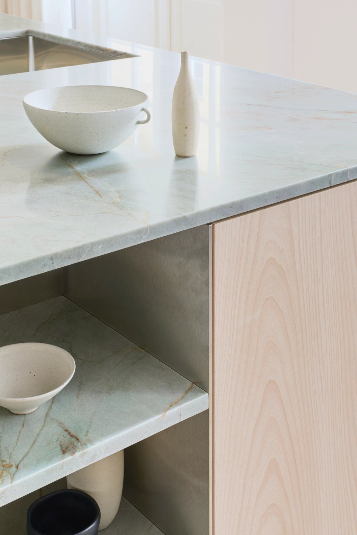 Detail view of stone shelves in light ash wooden kitchen island