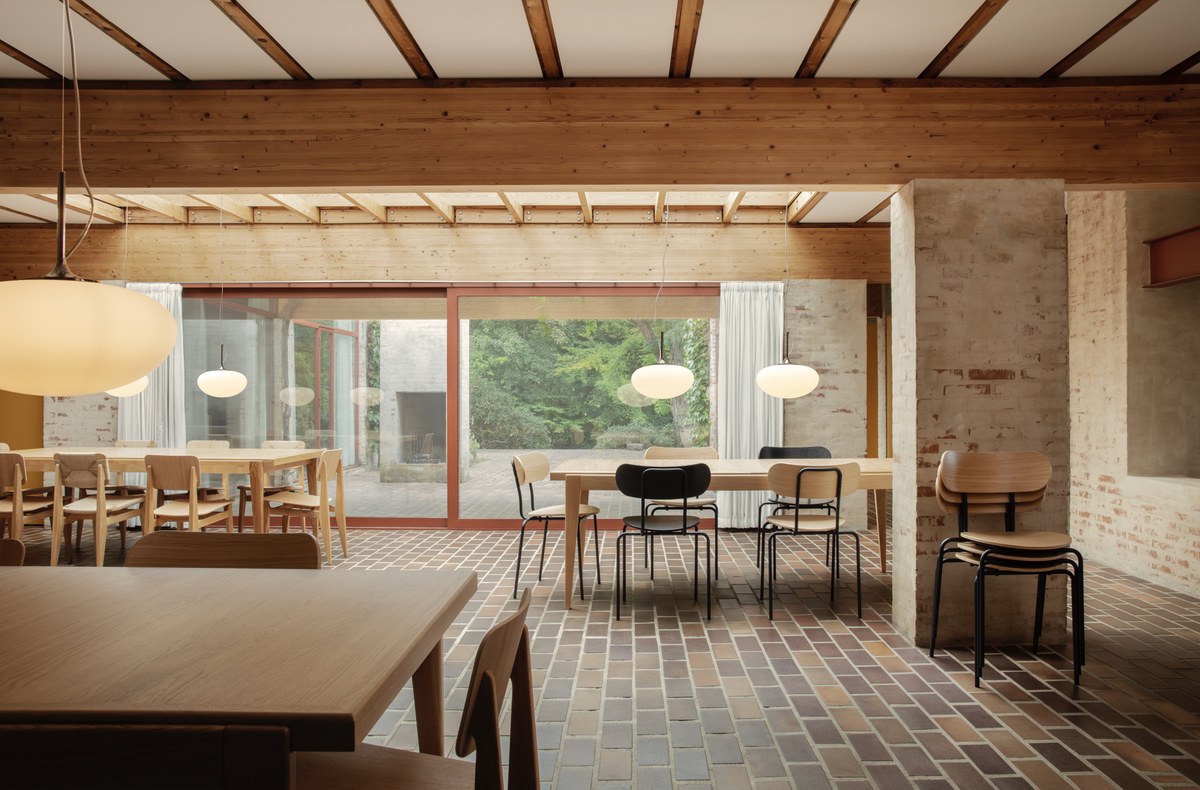 Large dining room with brick floor, tables and dining chairs